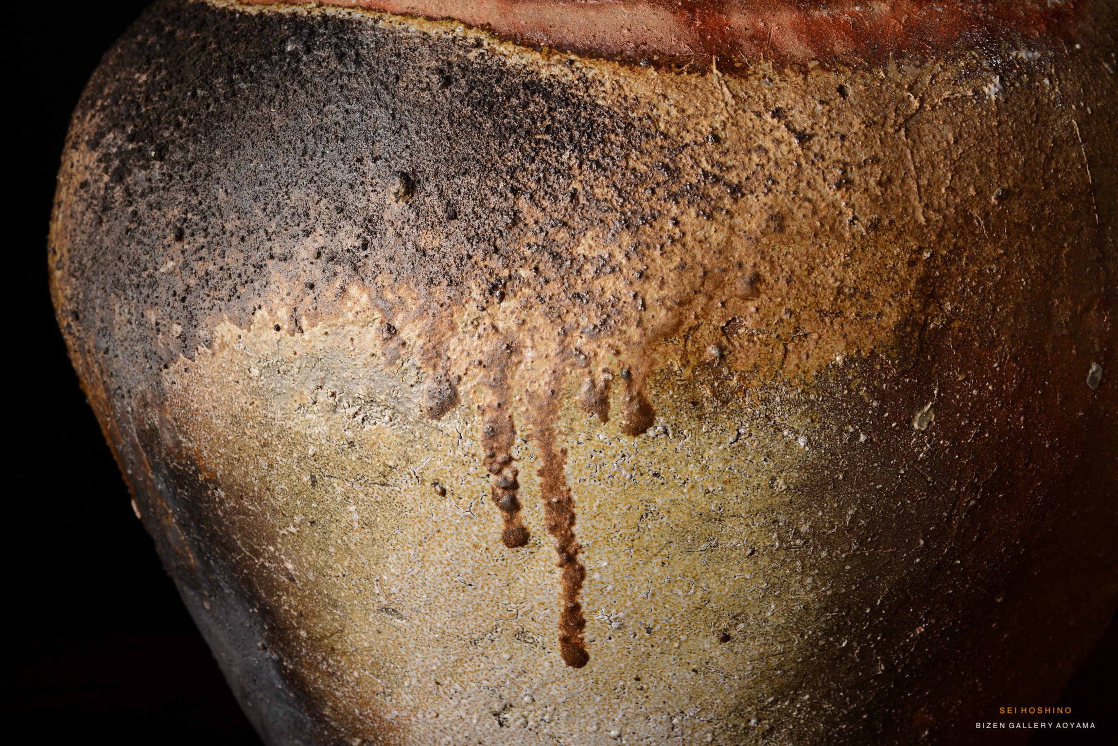 Close-up view of a Bizen pottery vase showcasing textured surfaces with earthy tones and drip patterns.