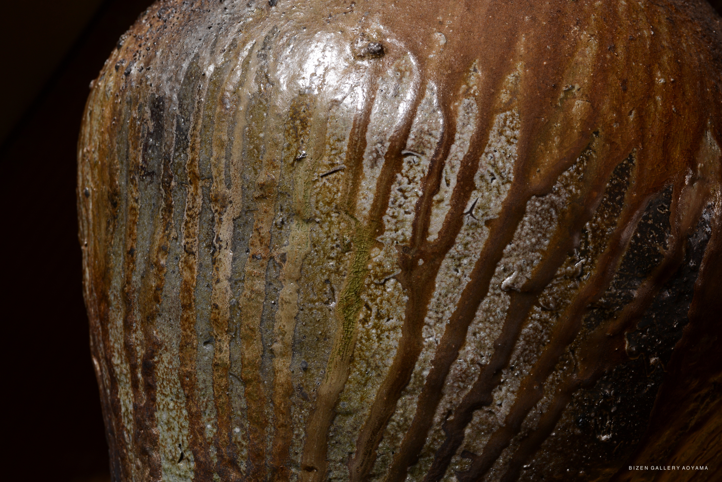 Close-up view of a Bizen otsubo showcasing its textured surface and natural glaze patterns, emphasizing earthy tones and organic lines.