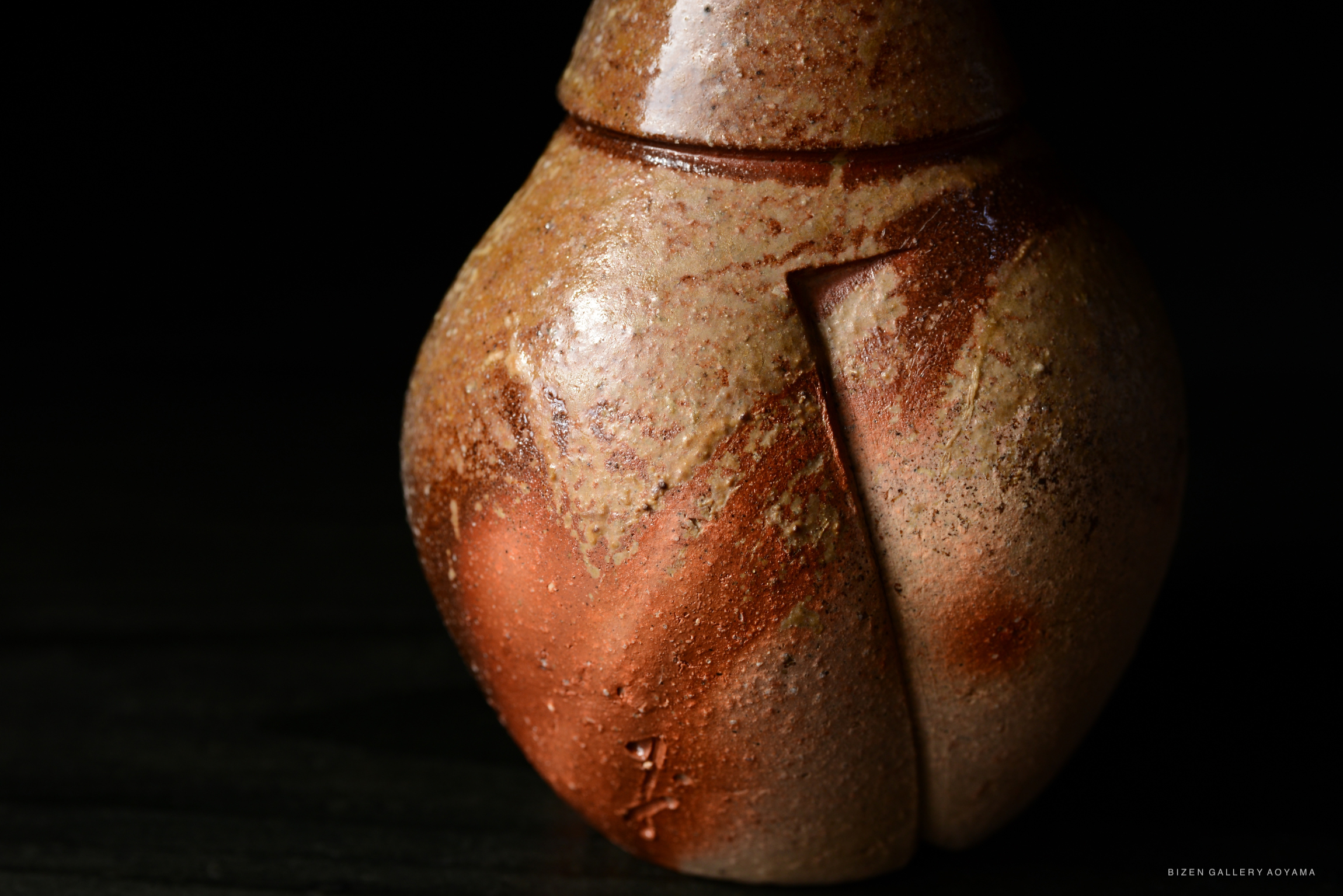 A close-up of a Bizen Tokkuri, showcasing its unique textured surface and natural clay colors.