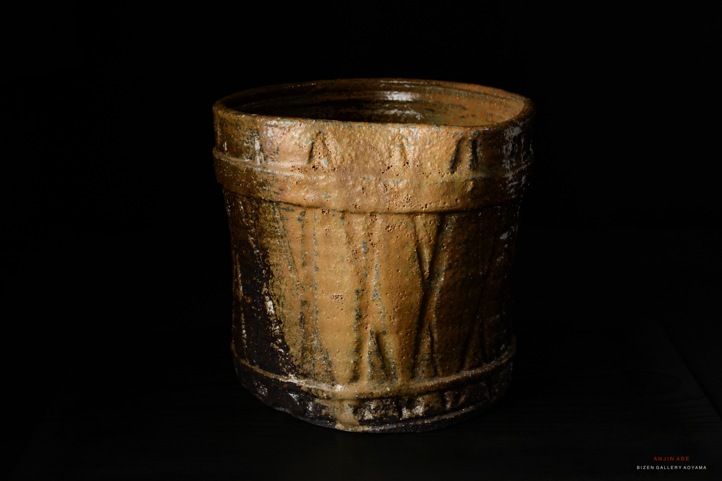 A rustic ceramic Mizusashi (water container) with a textured surface and an earthy brown color, showcasing traditional Japanese pottery craftsmanship.
