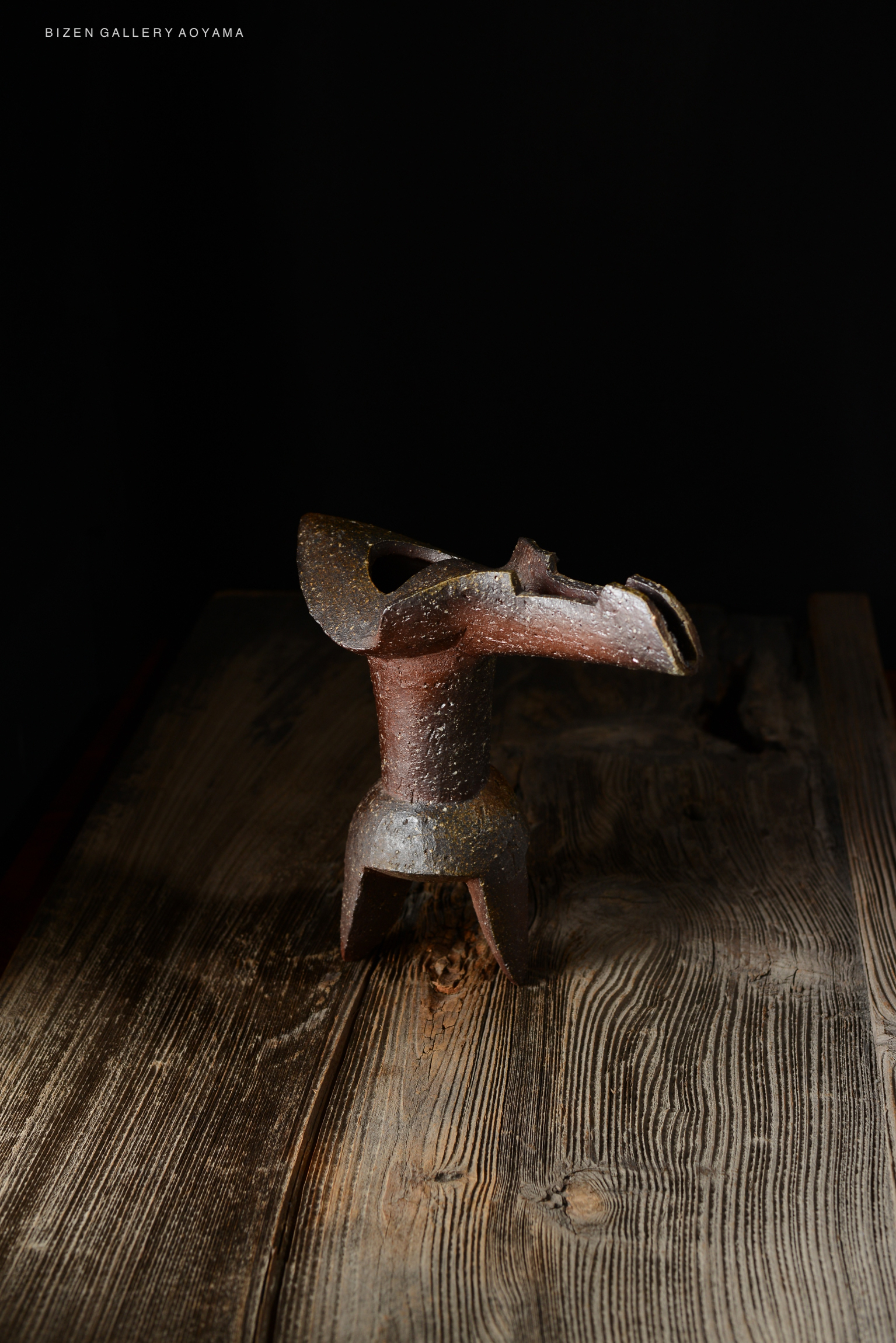 A traditional Japanese ceramic vase known as 'Hanaire Shaku', displayed on a wooden surface against a dark background.