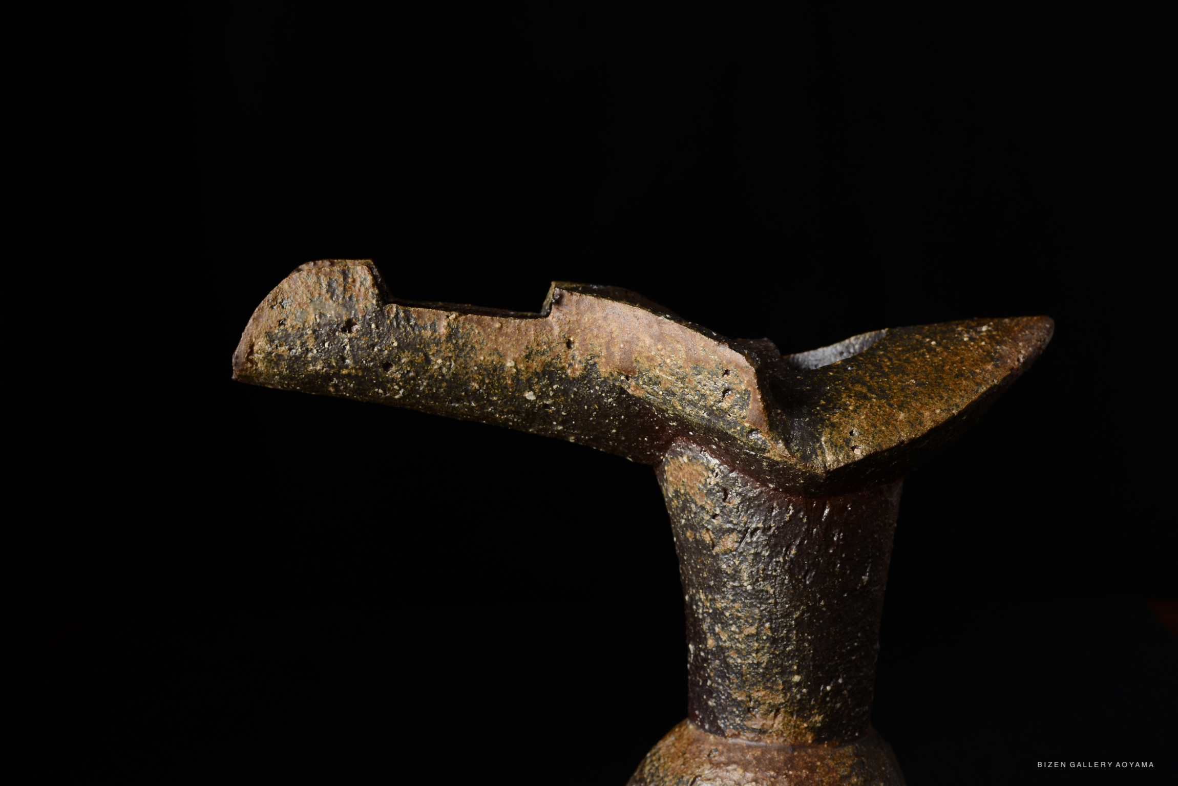 Close-up view of a Hanaire Shaku, a traditional Japanese flower vase, showcasing its unique angular design and textured surface against a dark background.