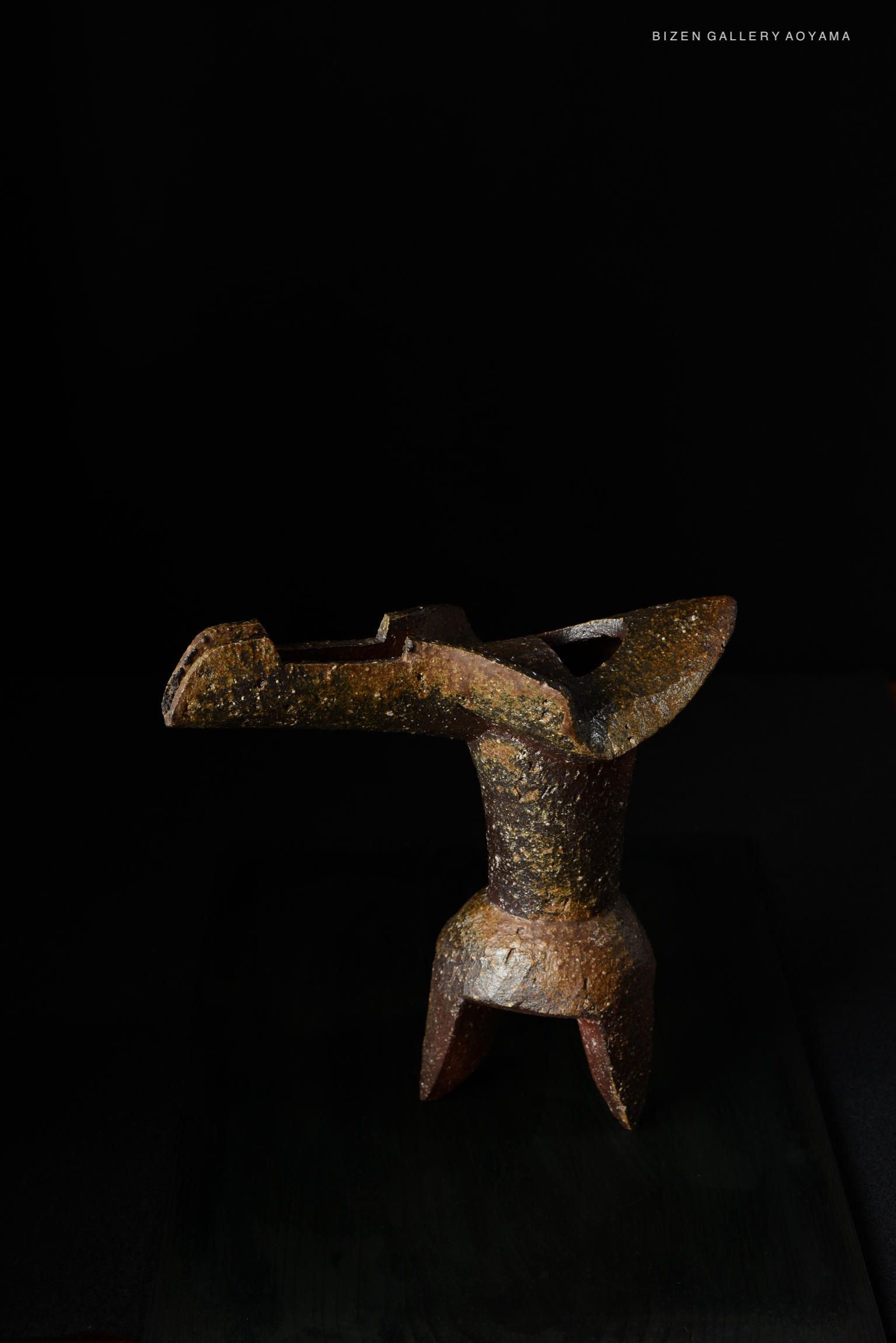 A ceramic hanaire (flower vase) with a unique shape and a textured surface, displayed against a black background.