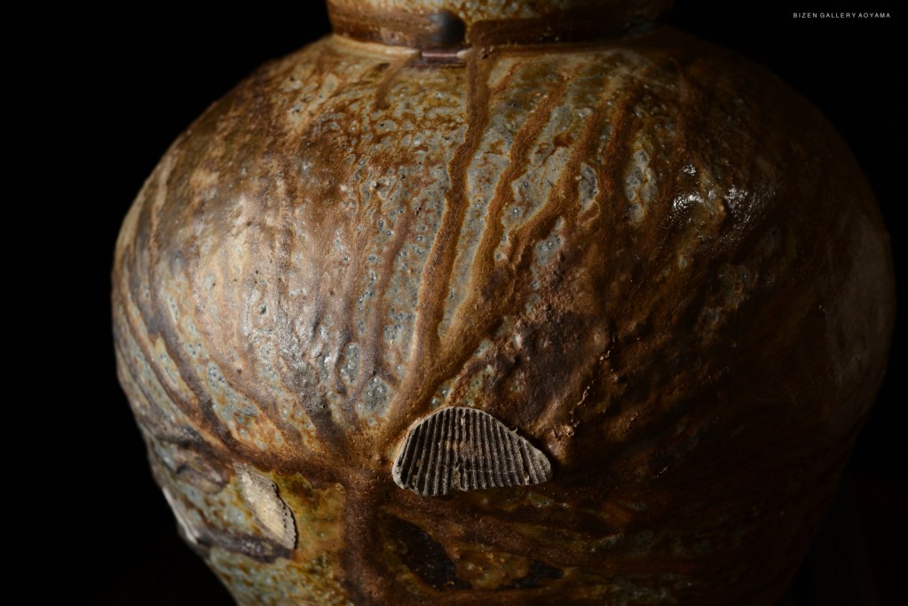 Close-up view of a Bizen pottery vase showcasing its unique textured surface and natural glaze.