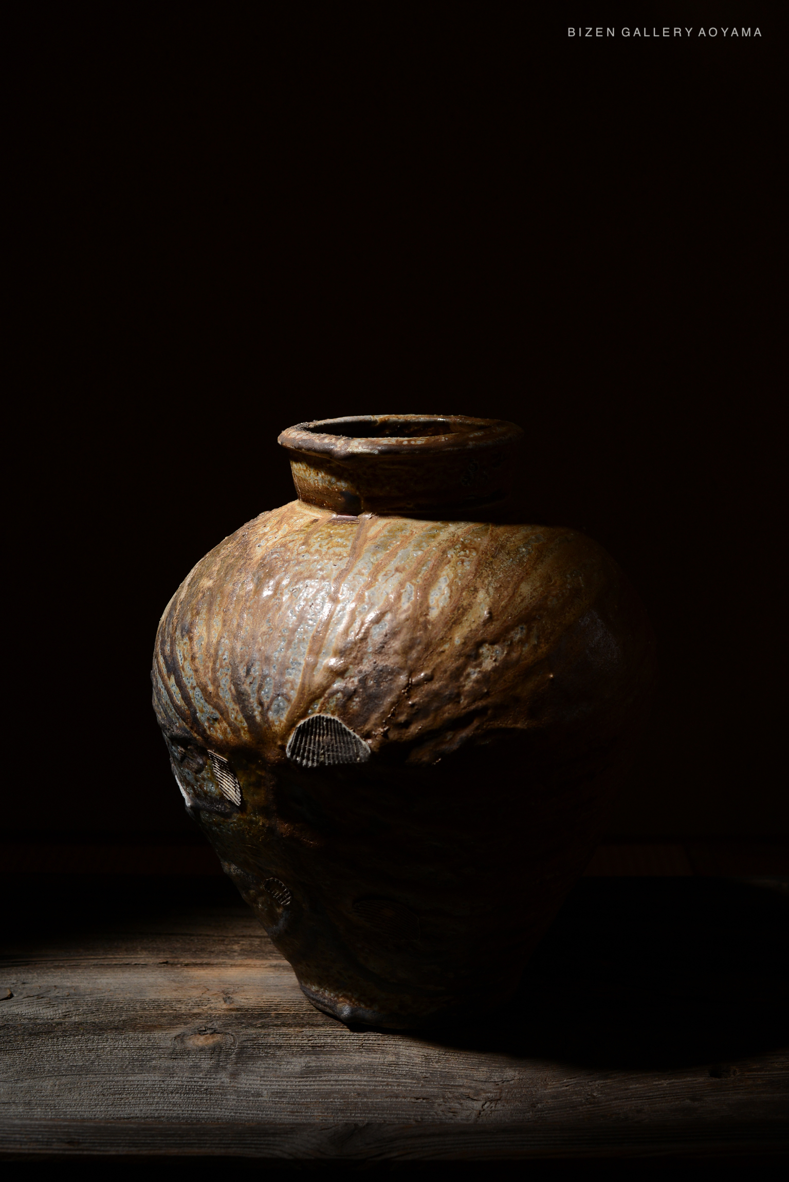 A decorative ceramic vessel with a textured surface, partially illuminated, showcasing its unique patterns and earthy tones.