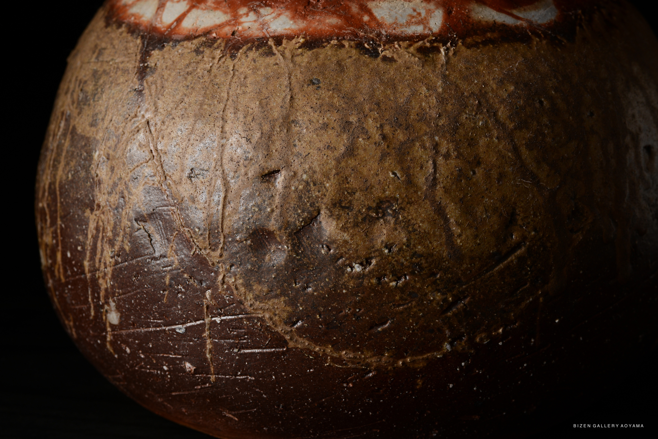 Close-up of a Bizen pottery Tokkuri featuring a textured surface with earthy tones and subtle variations in color.