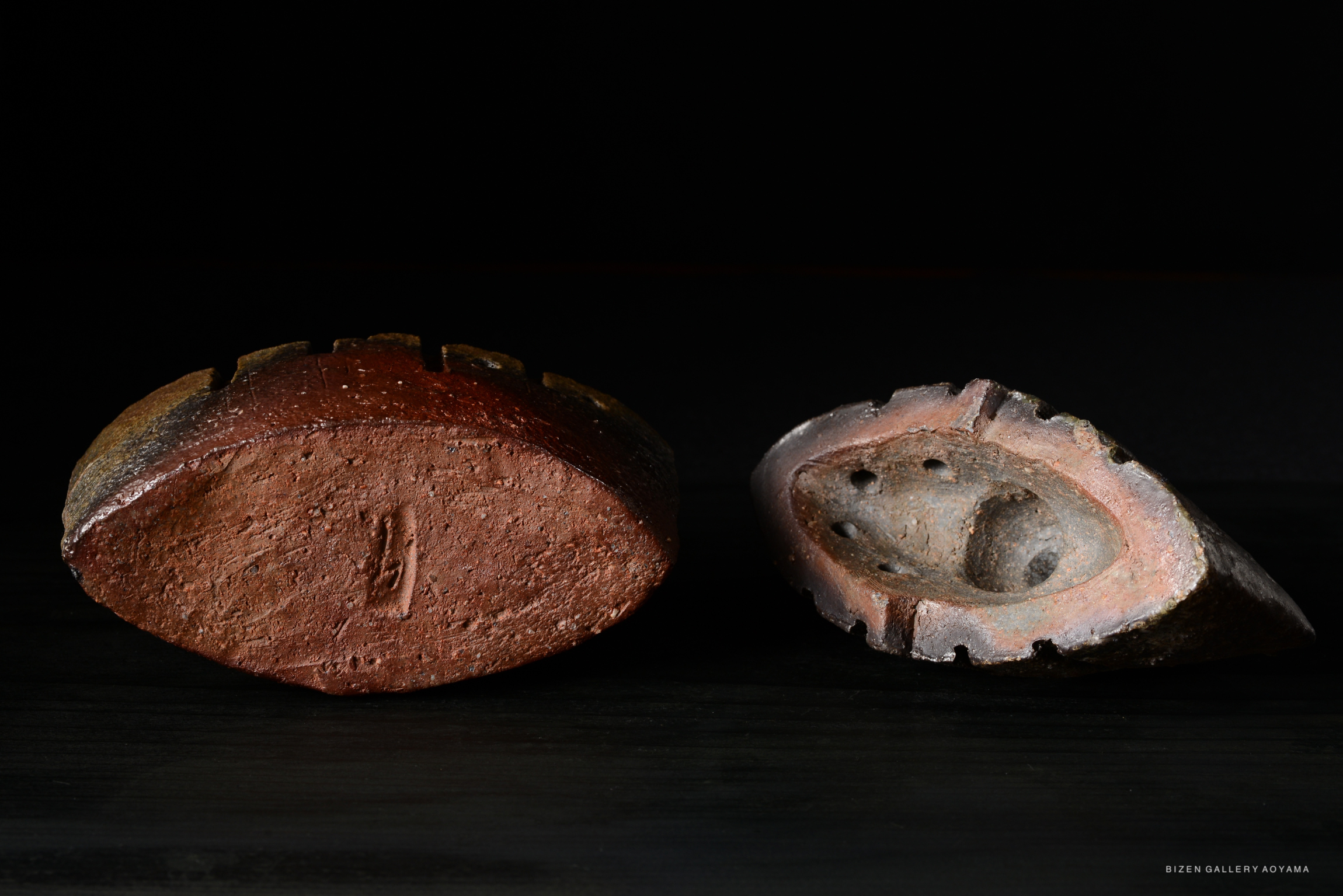 Two traditional Japanese incense burners made of clay, showcased from an angled top view. The one on the left has a darker finish with prominent ridges, while the right one is lighter with a smooth texture and visible holes.