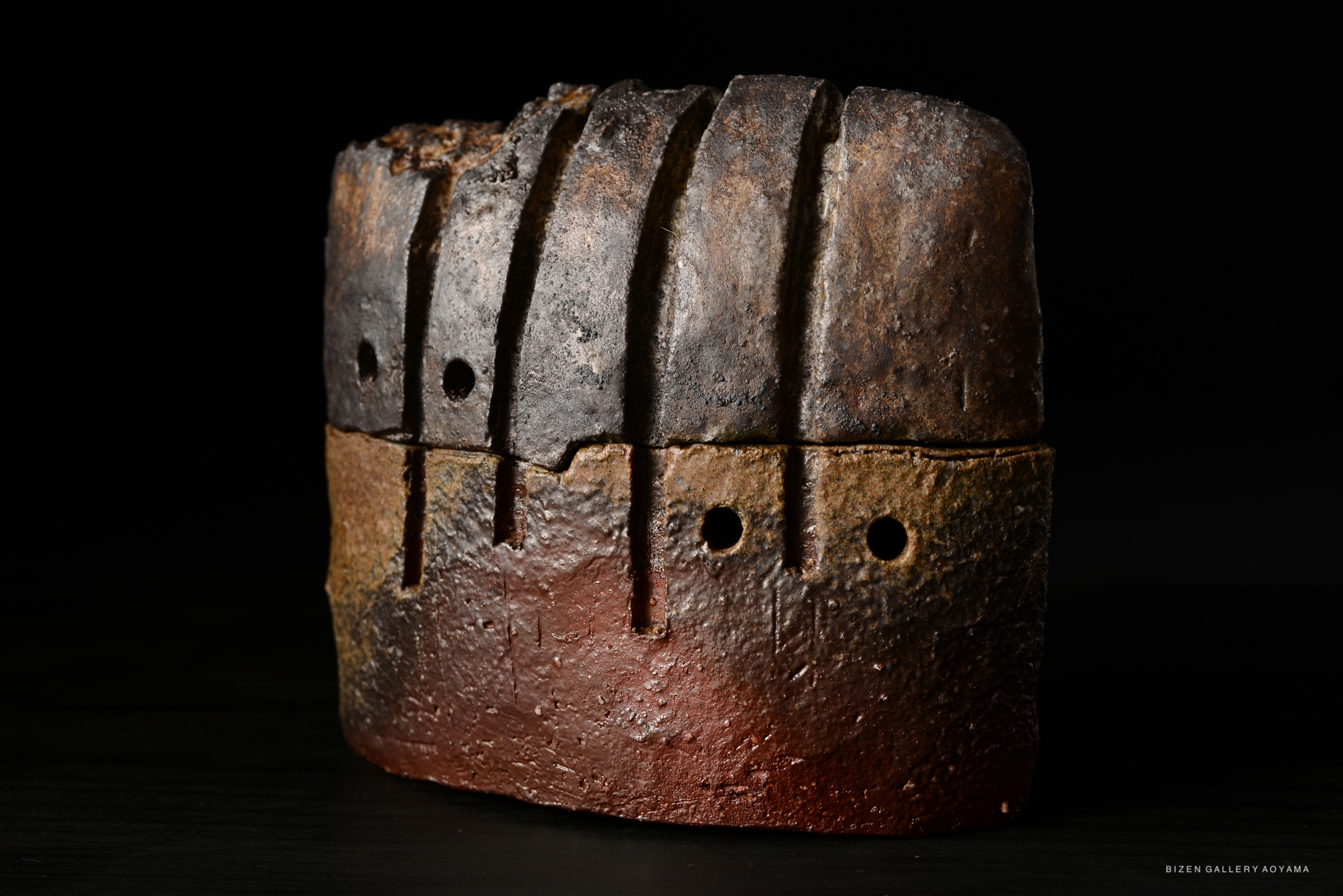 A ceramic incense burner with a rustic design, featuring multiple grooves and holes, showcasing earthy tones of brown and gray.