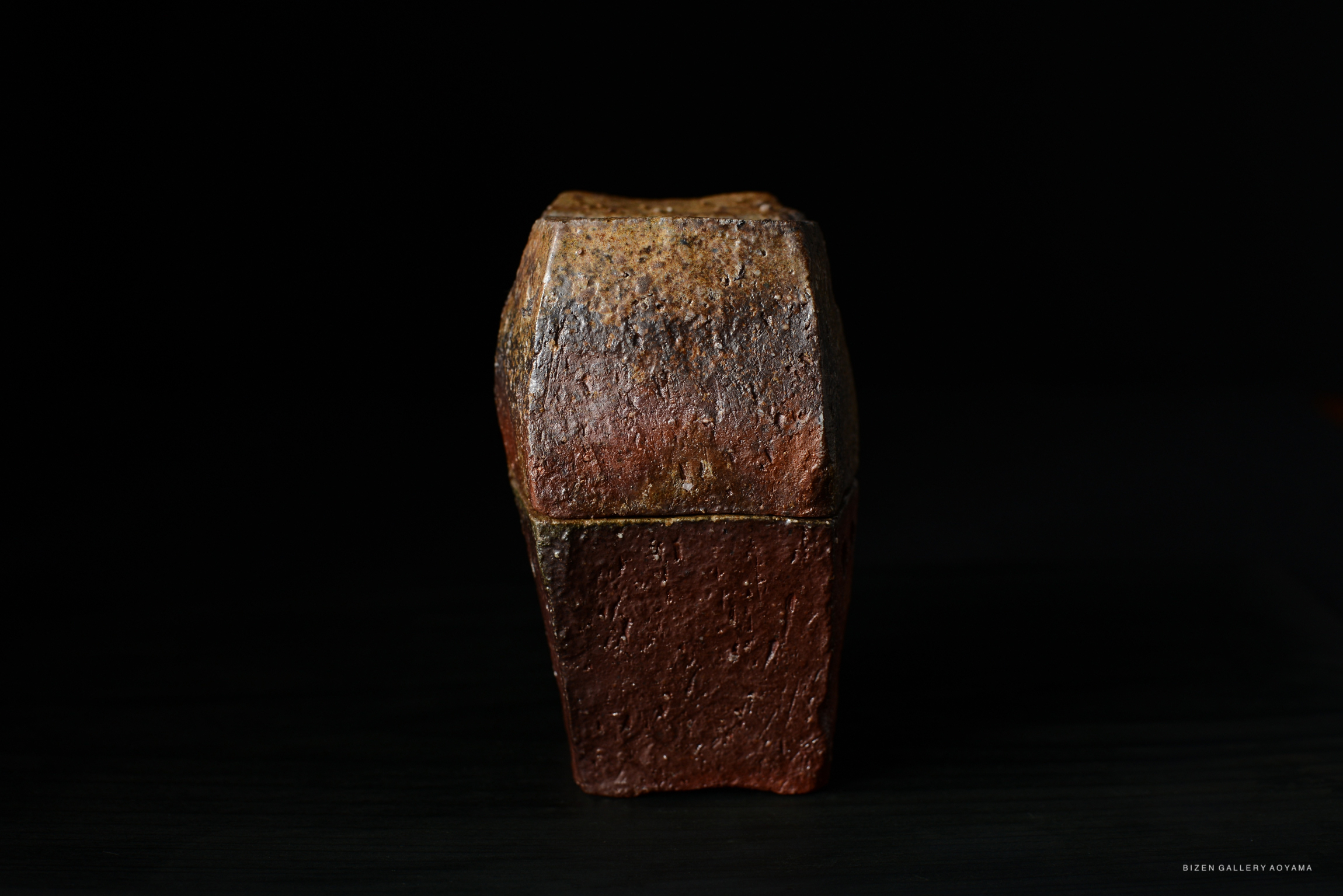 A close-up image of a Bizen pottery incense burner, showcasing its textured surface and earthy colors against a dark background.