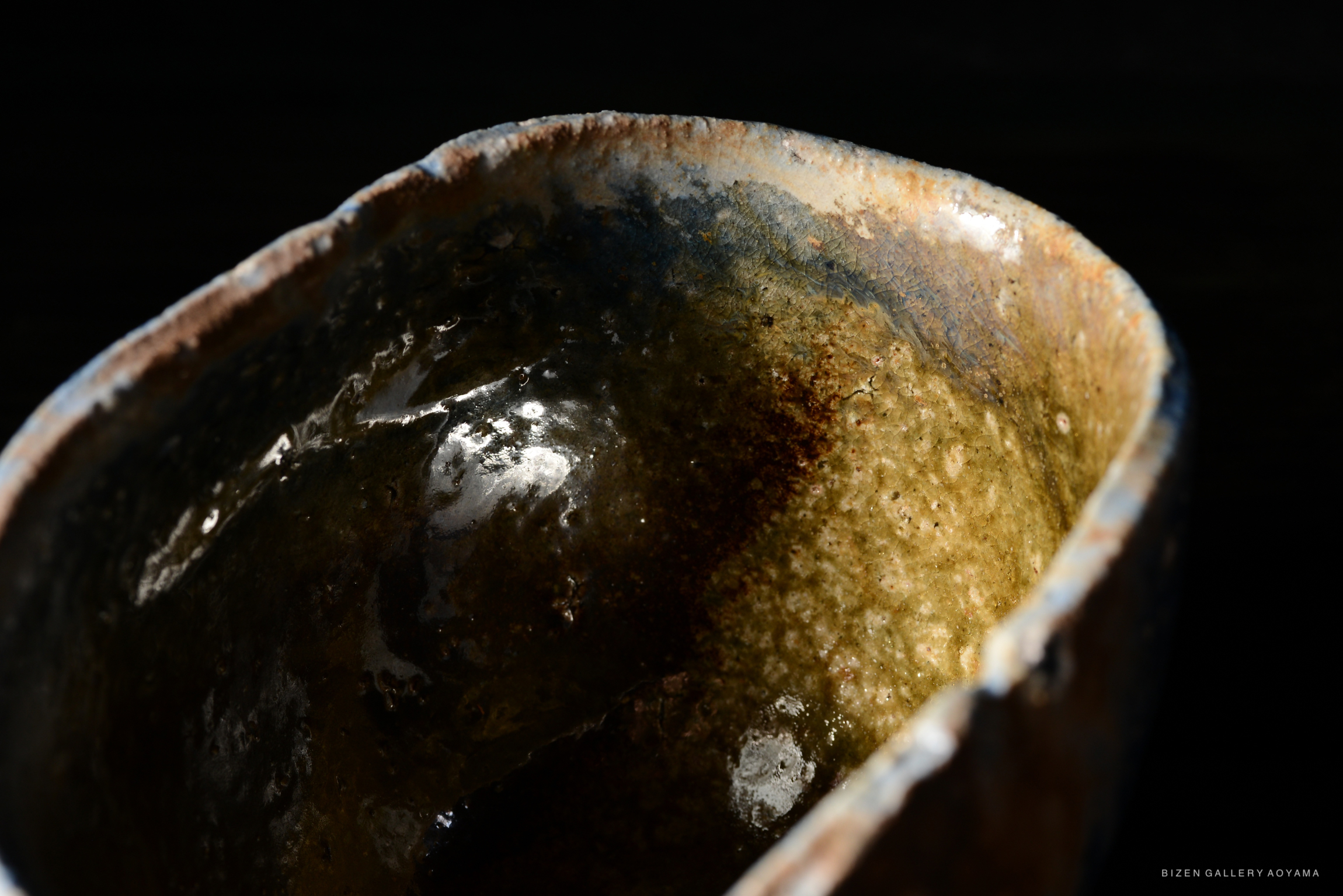 Close-up view of a handcrafted black ceramic bowl, showcasing its unique texture and glaze details.