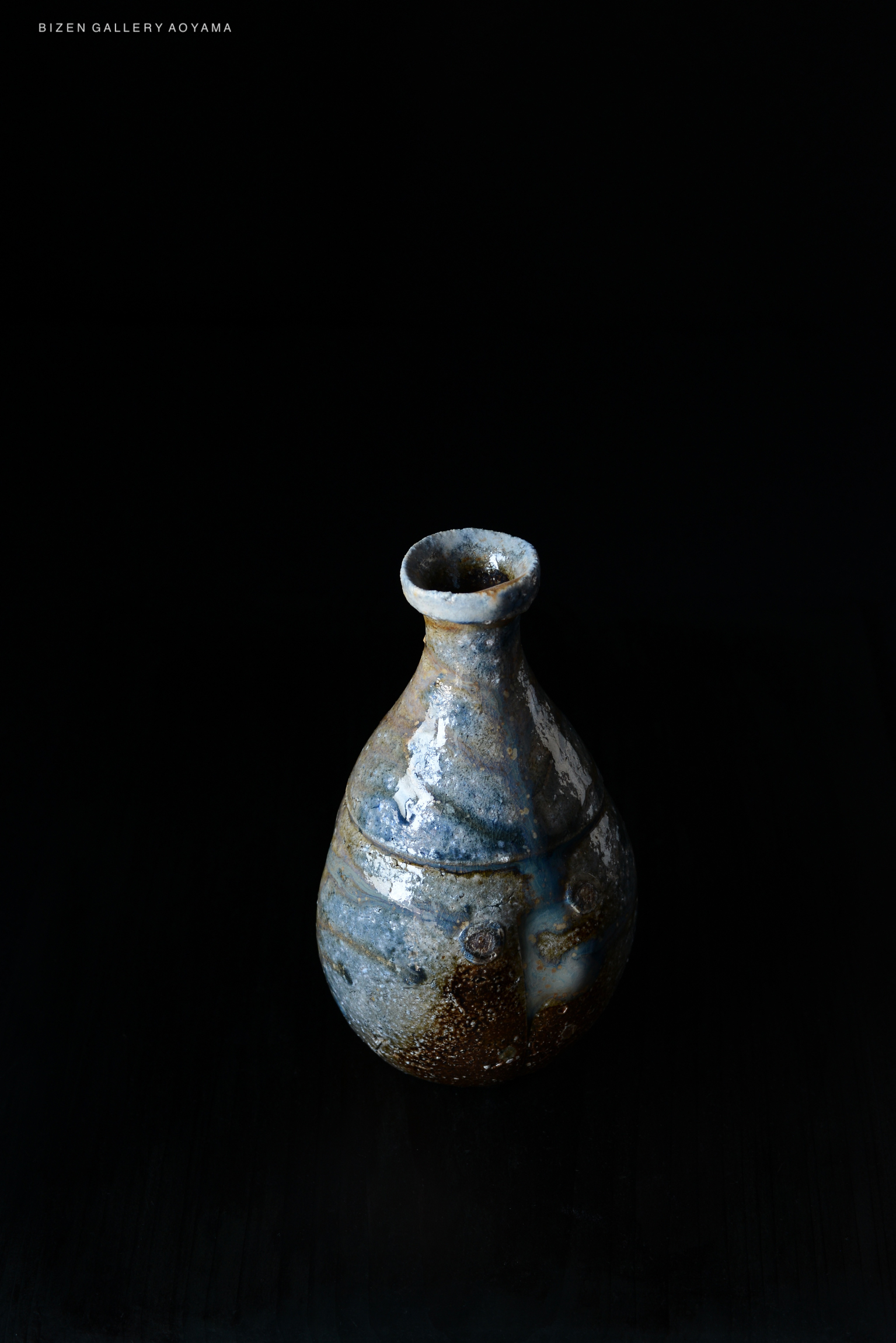 A traditional Bizen pottery vase with a unique shape and glaze, set against a dark background.