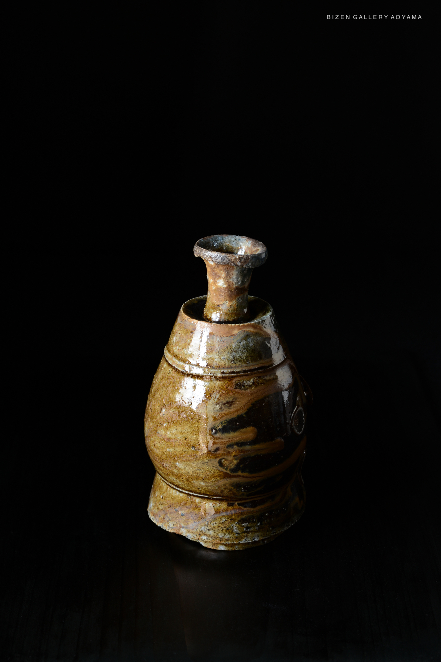 A traditional Japanese Kuro Tokkuri, a sake vessel, displayed against a black background.