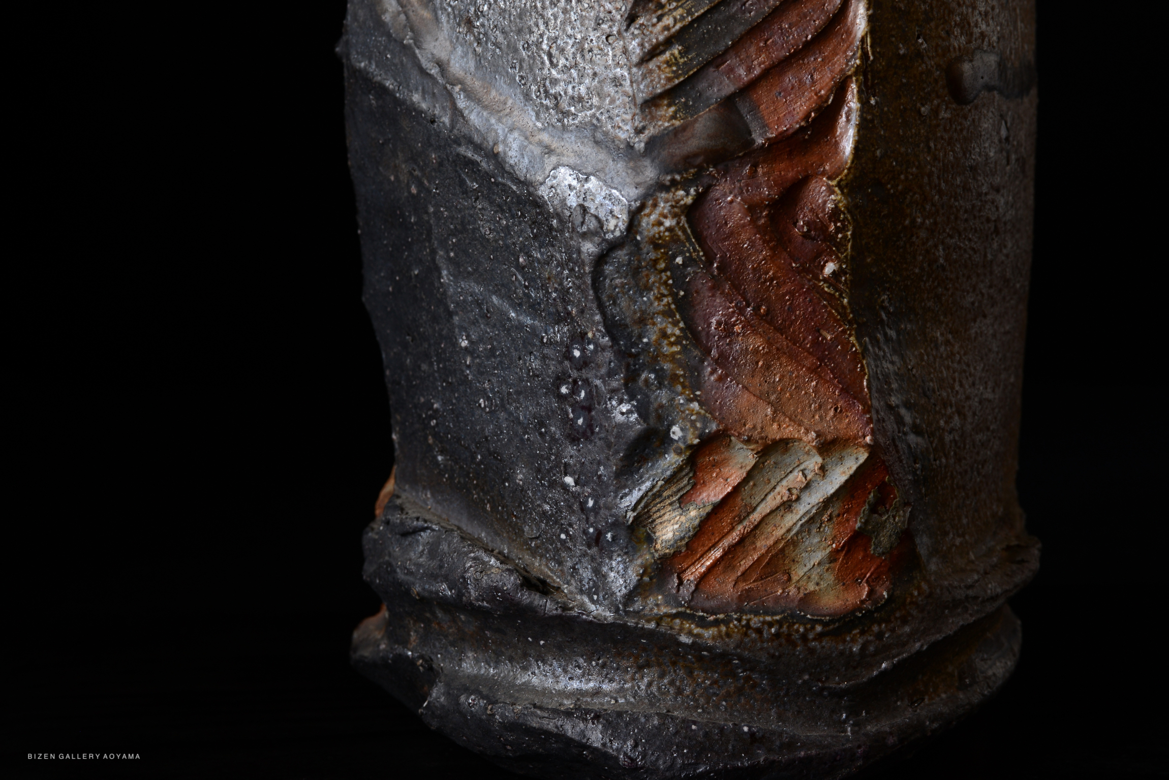 Close-up of a ceramic piece showcasing intricate textural details and earthy colors, emphasizing the unique craftsmanship.