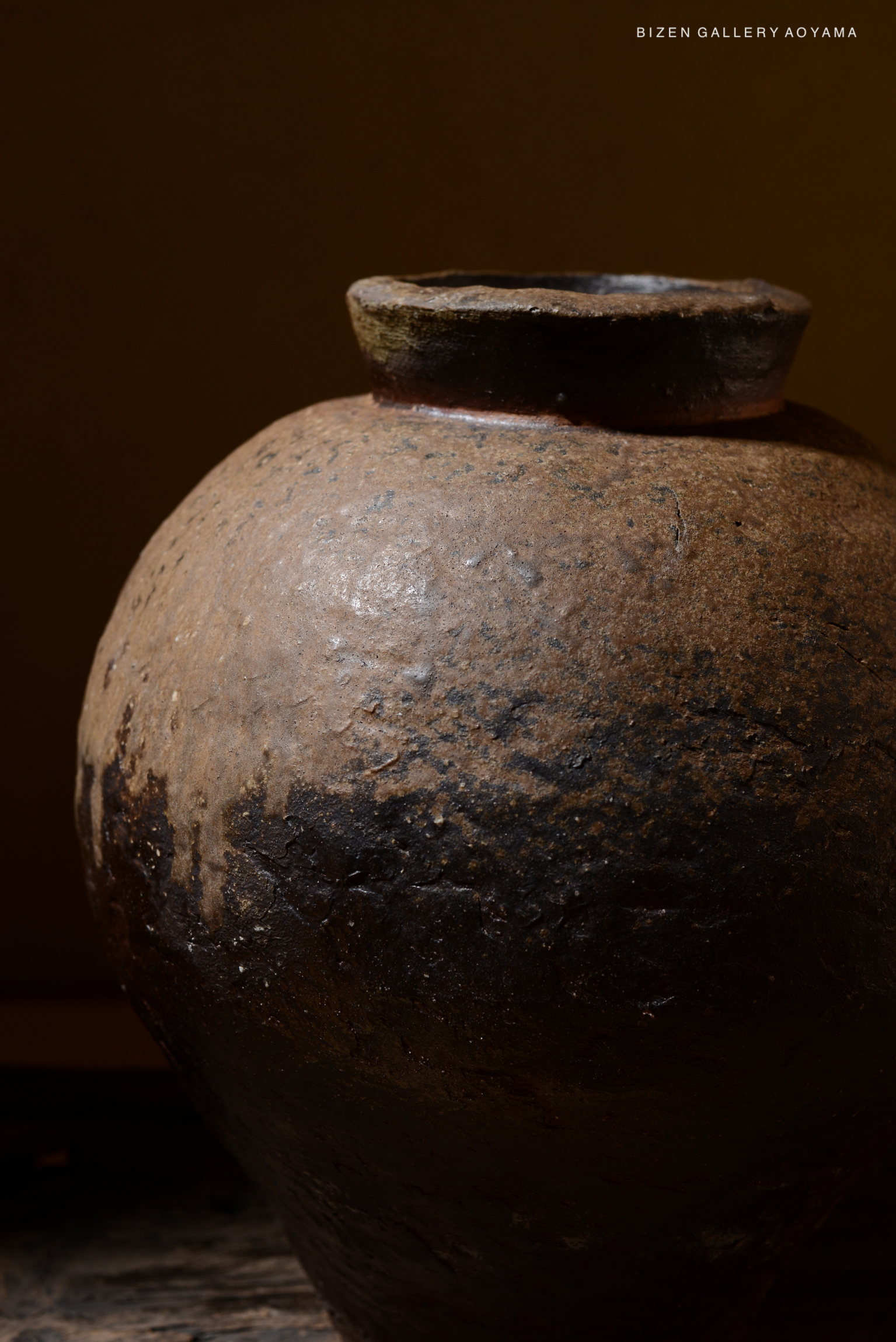 Close-up view of a traditional Bizen pottery tsubo, showcasing the unique textures and earthy colors of the ceramic.