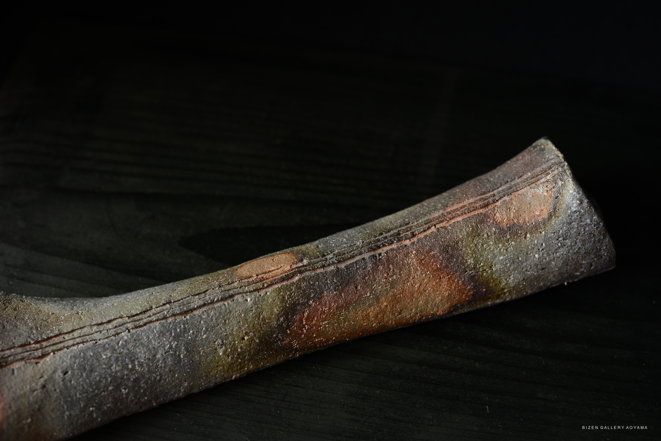 Close-up of a textured ceramic piece with earthy colors and a rough surface.