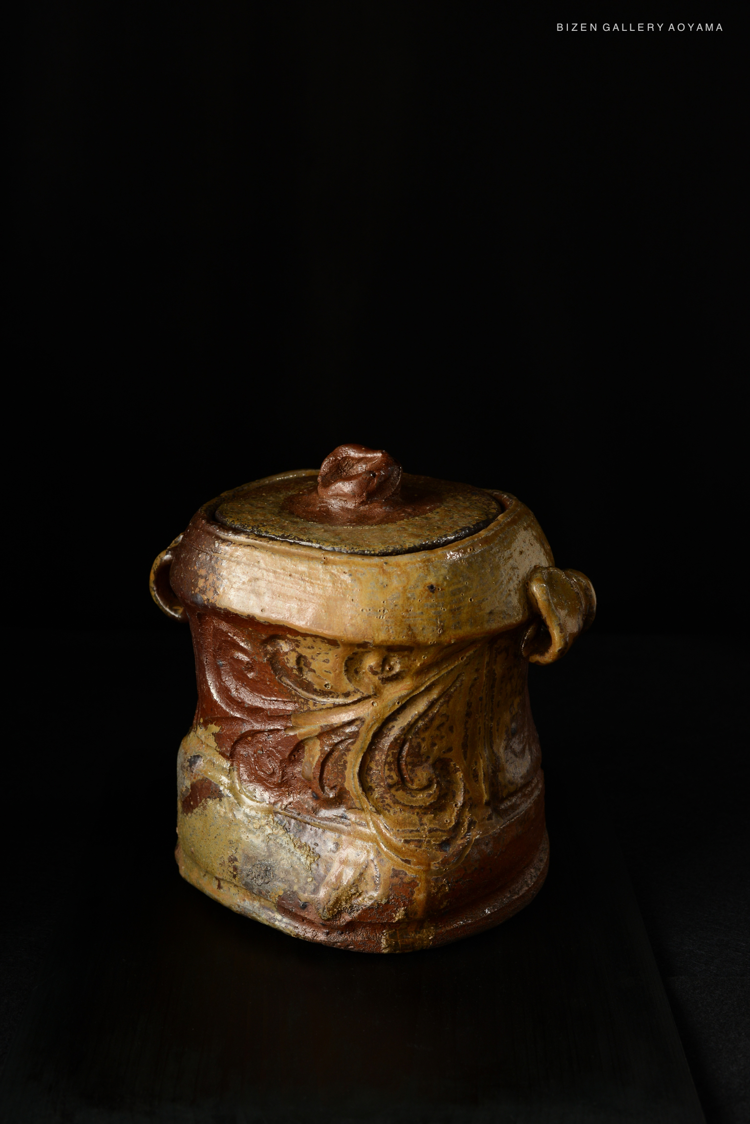 A beautifully crafted Bizen Mizusashi with intricate textures and colors, featuring a lid with a decorative knob and two side handles.
