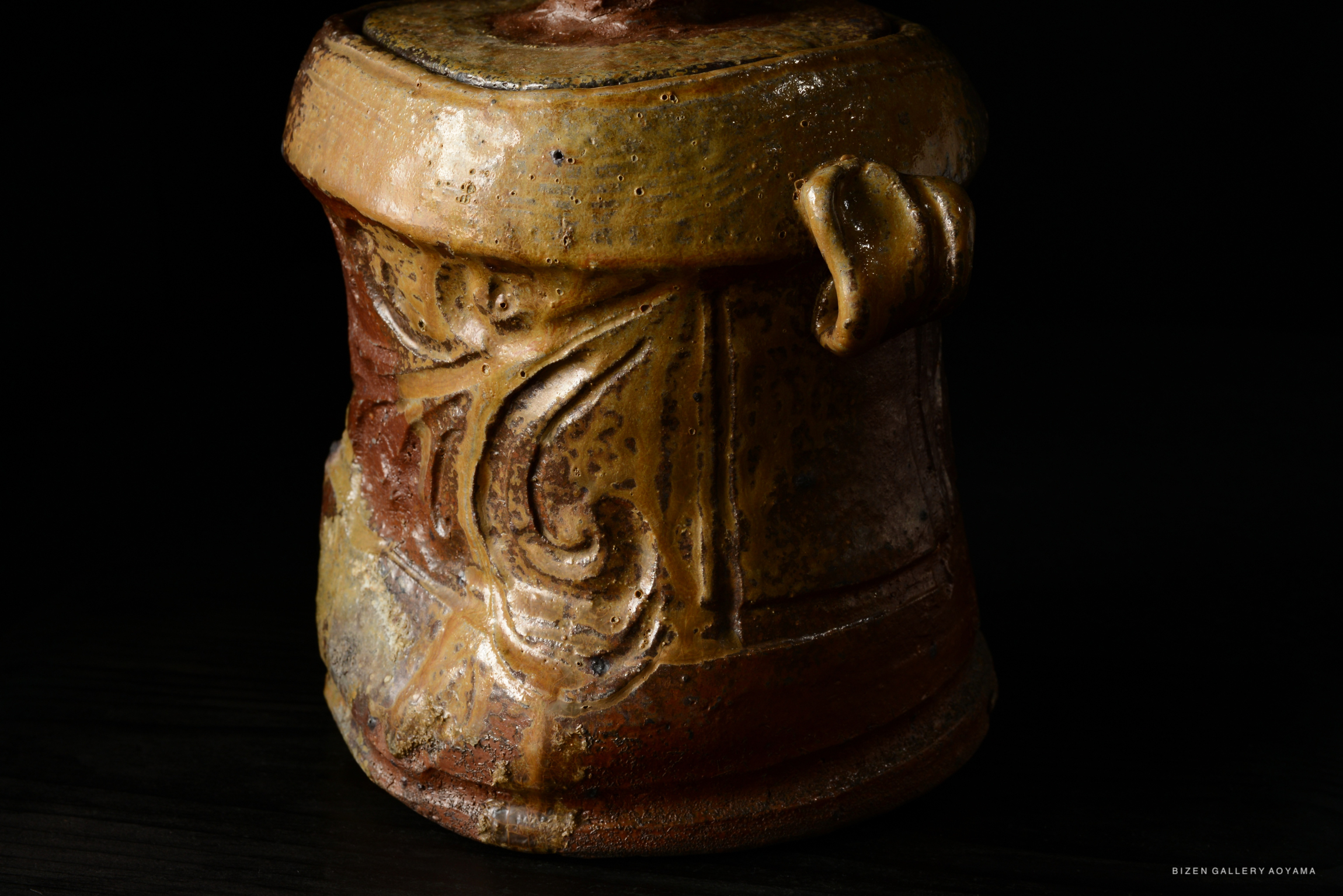 A close-up of a Bizen Mizusashi, showcasing intricate designs and earthy colors, highlighting the texture and craftsmanship.