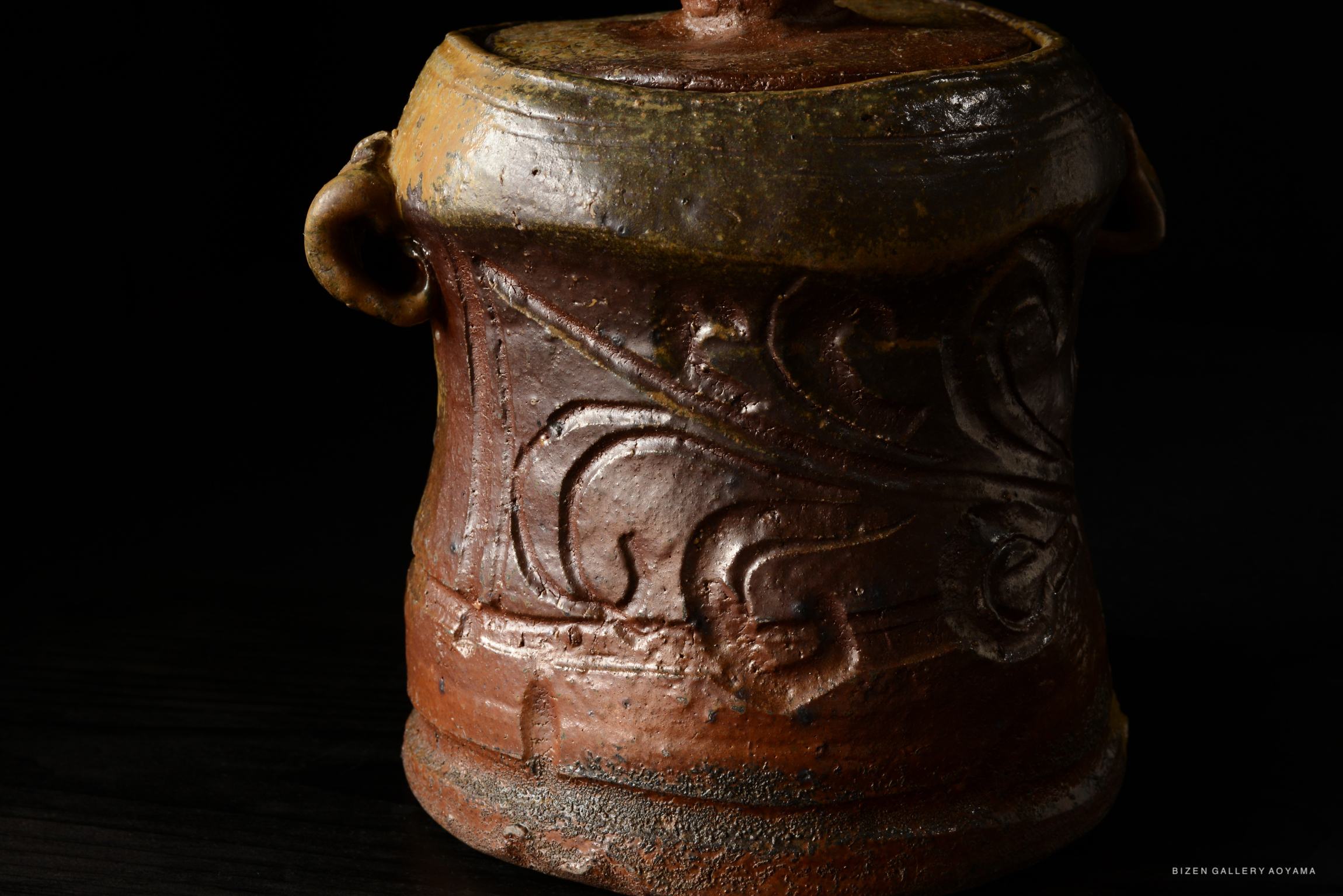 close-up of a Bizen Mizusashi ceramic pot with intricate carvings and a rustic finish