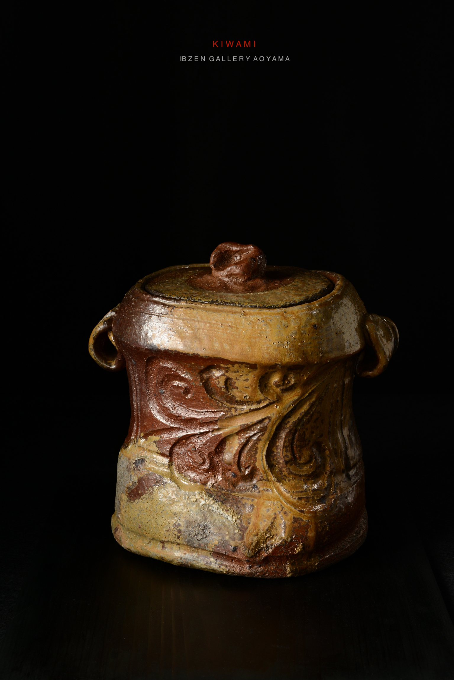 A textured ceramic container with decorative patterns and a lid, displaying unique colors and craftsmanship, set against a dark background.