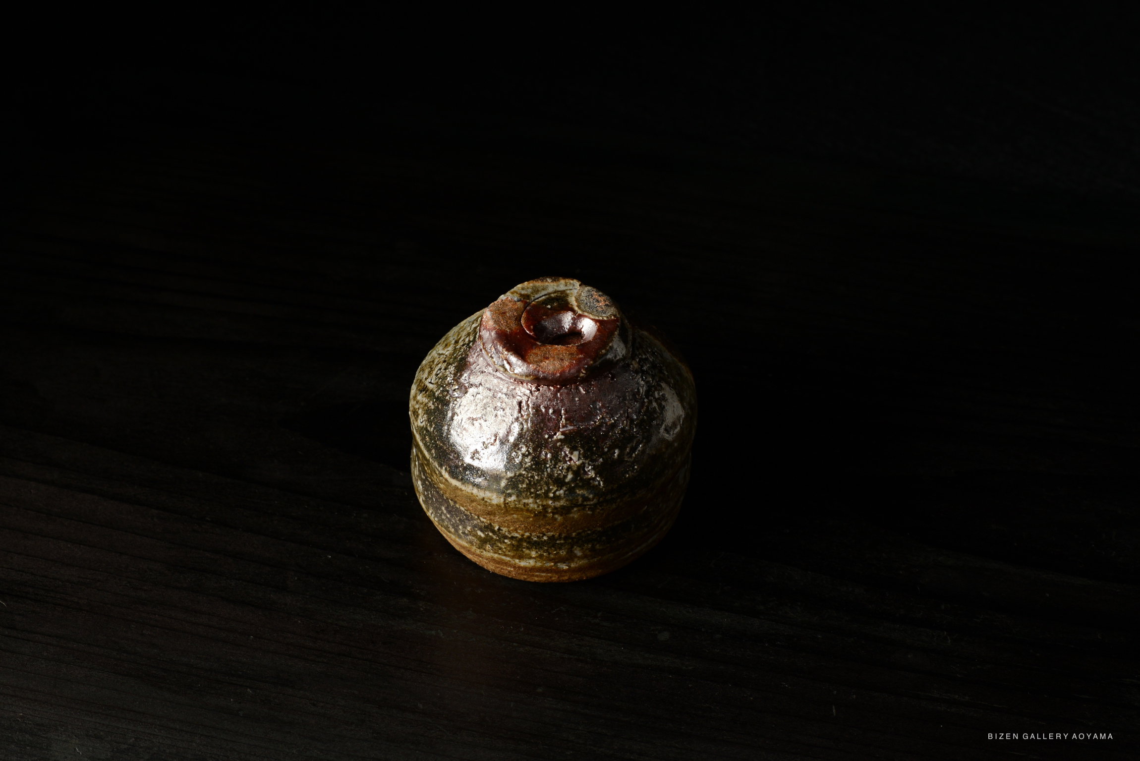 A Bizen Guinomi sake cup by artist Naoe Koide, featuring a unique, textured surface and earthy colors.