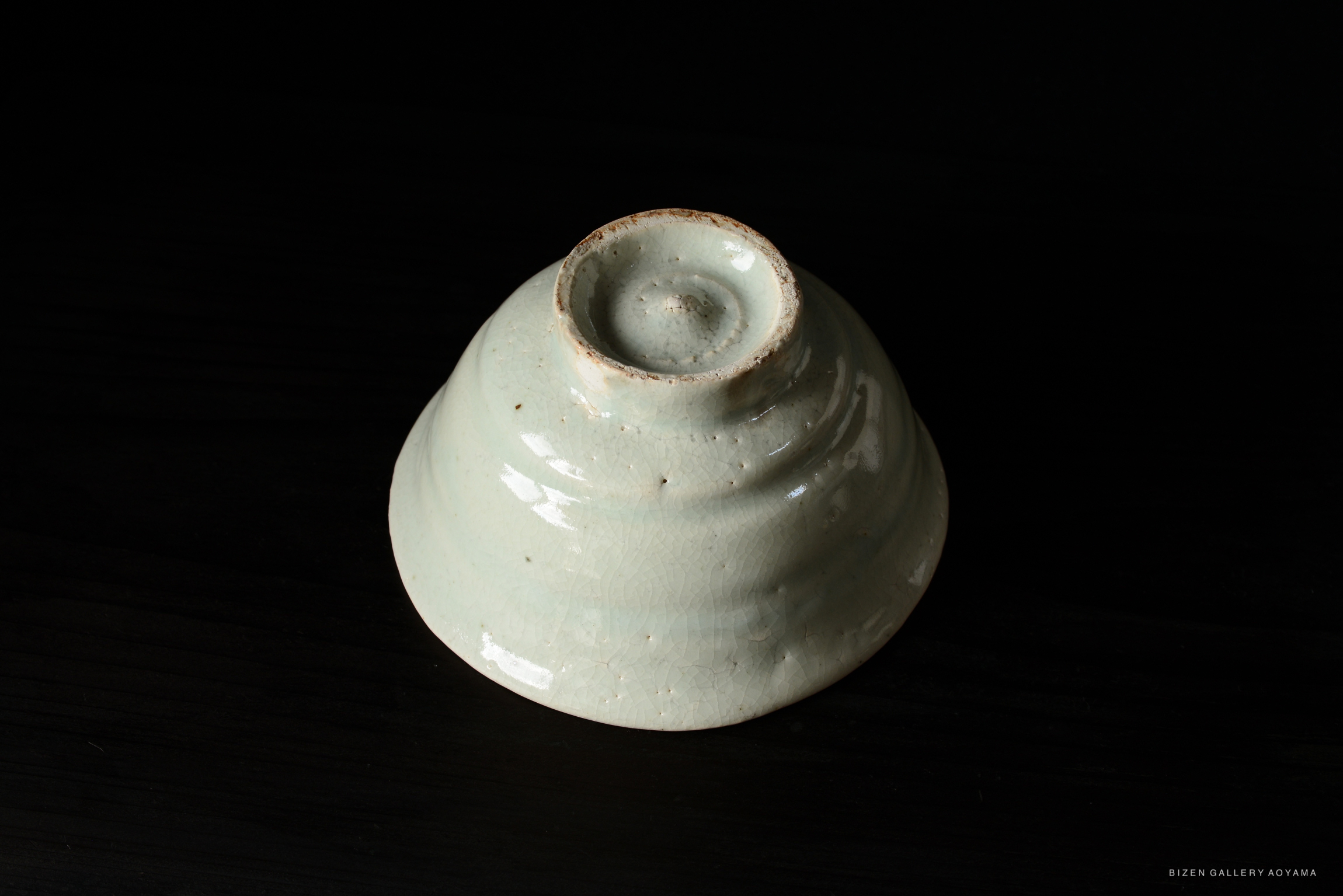 A ceramic bowl with a light glaze, featuring a rounded, flared shape and visible texture.
