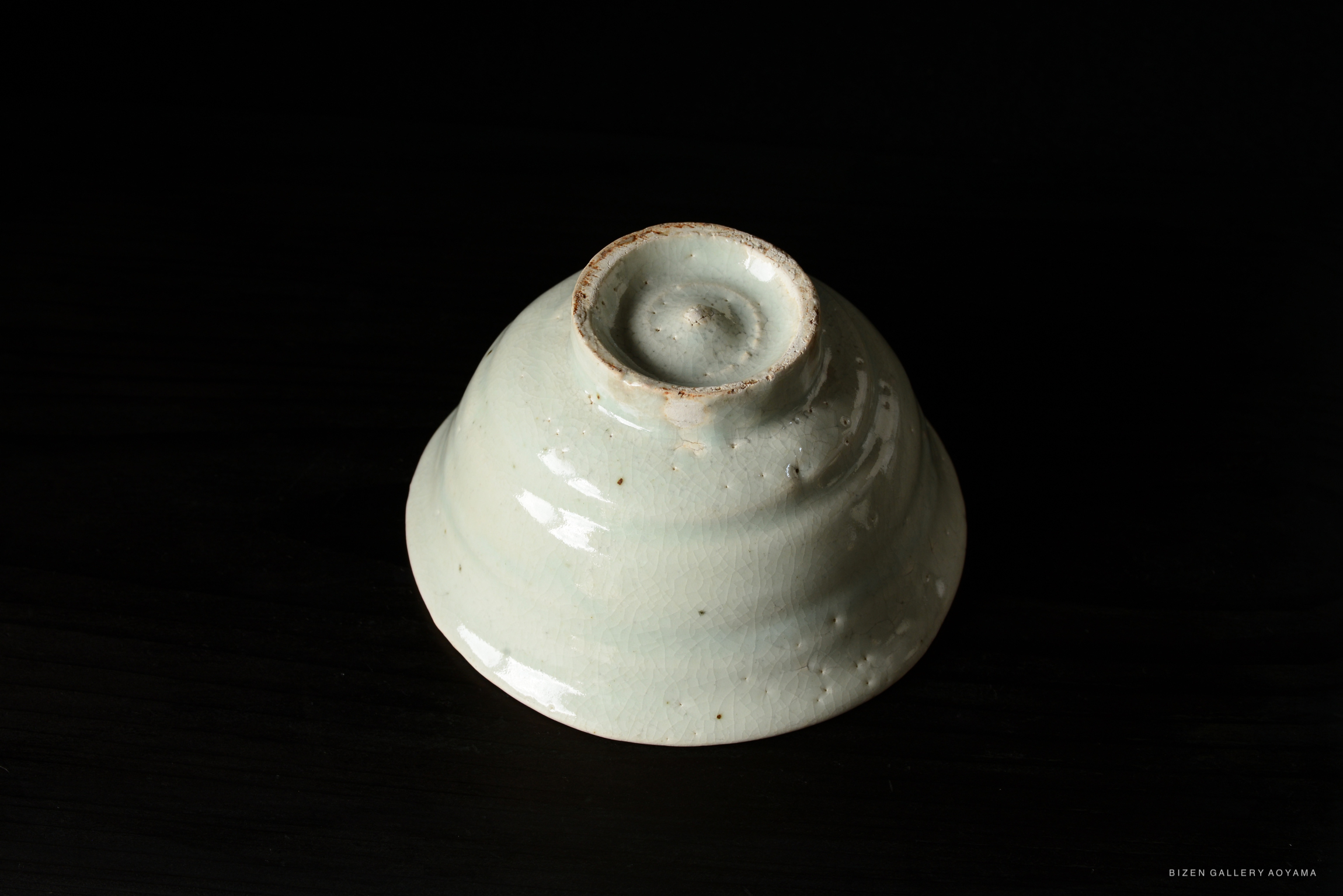 A light green ceramic bowl seen from the side, showcasing its smooth surface and slightly flared rim.
