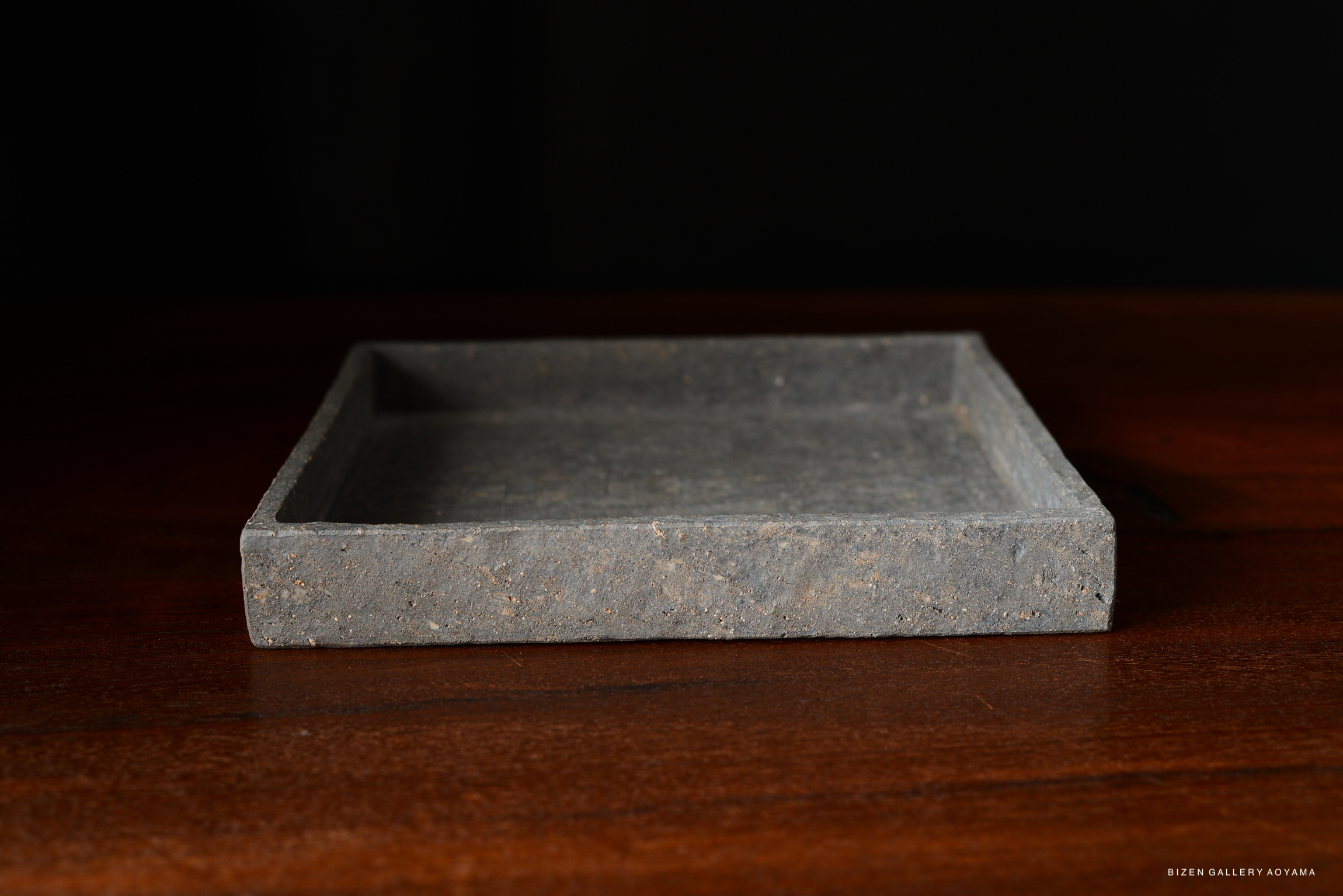 A simple and elegant square plate in a cool grey color, showcasing a smooth surface and clean lines.