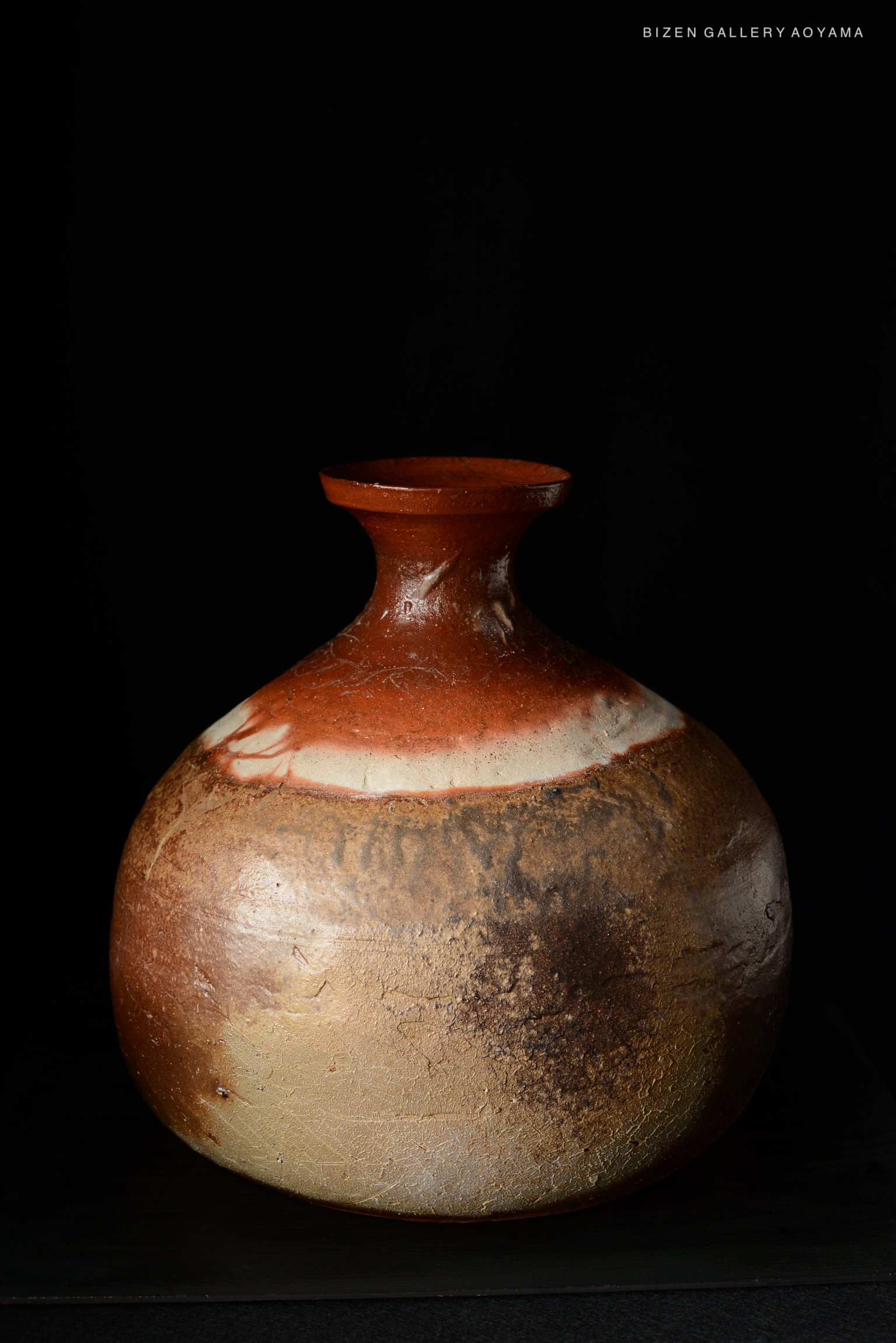 A traditional Bizen pottery Tokkuri with a rounded body and a narrow neck, showcasing natural earthy tones and textures.
