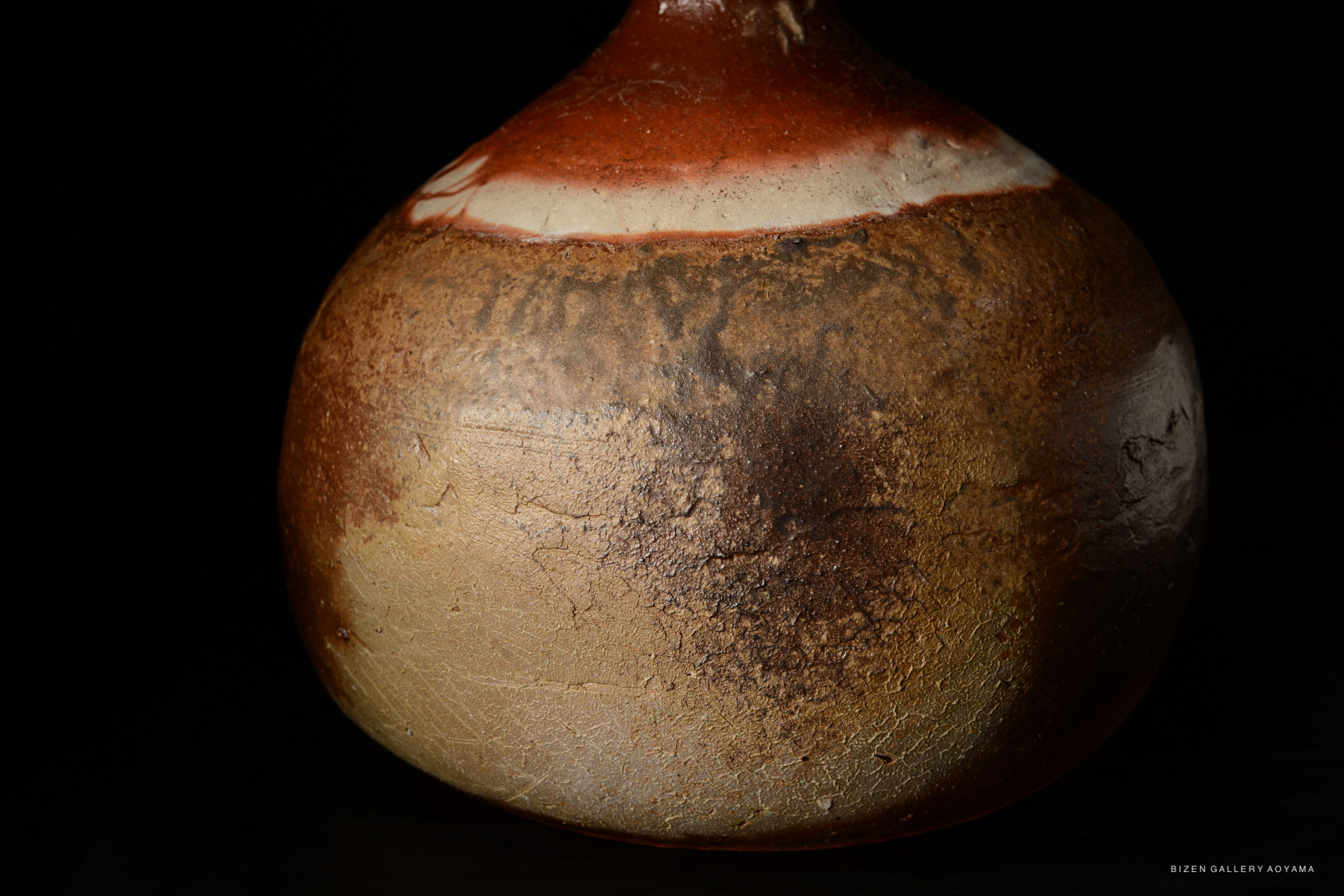 A close-up of a Bizen O Kabura Tokkuri, showcasing its textured, earthy surface and distinctive coloration.