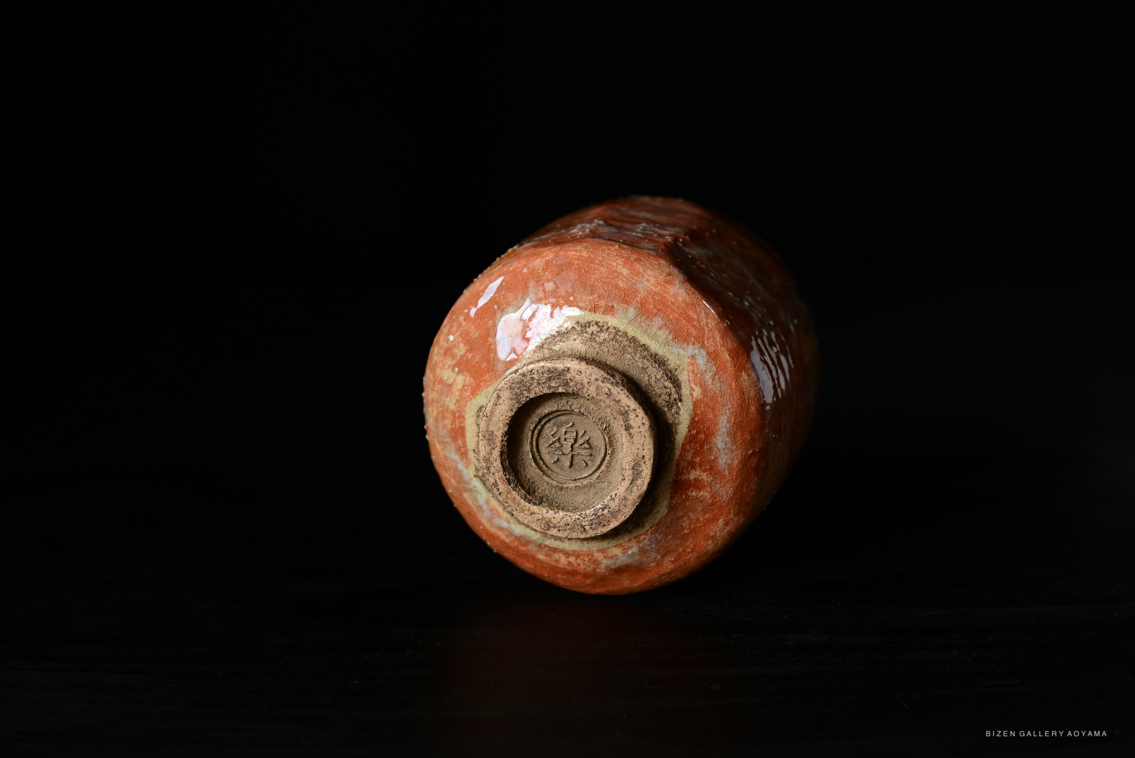 A close-up view of the bottom of a Bizen tea bowl, showcasing its distinctive glaze and inscription.