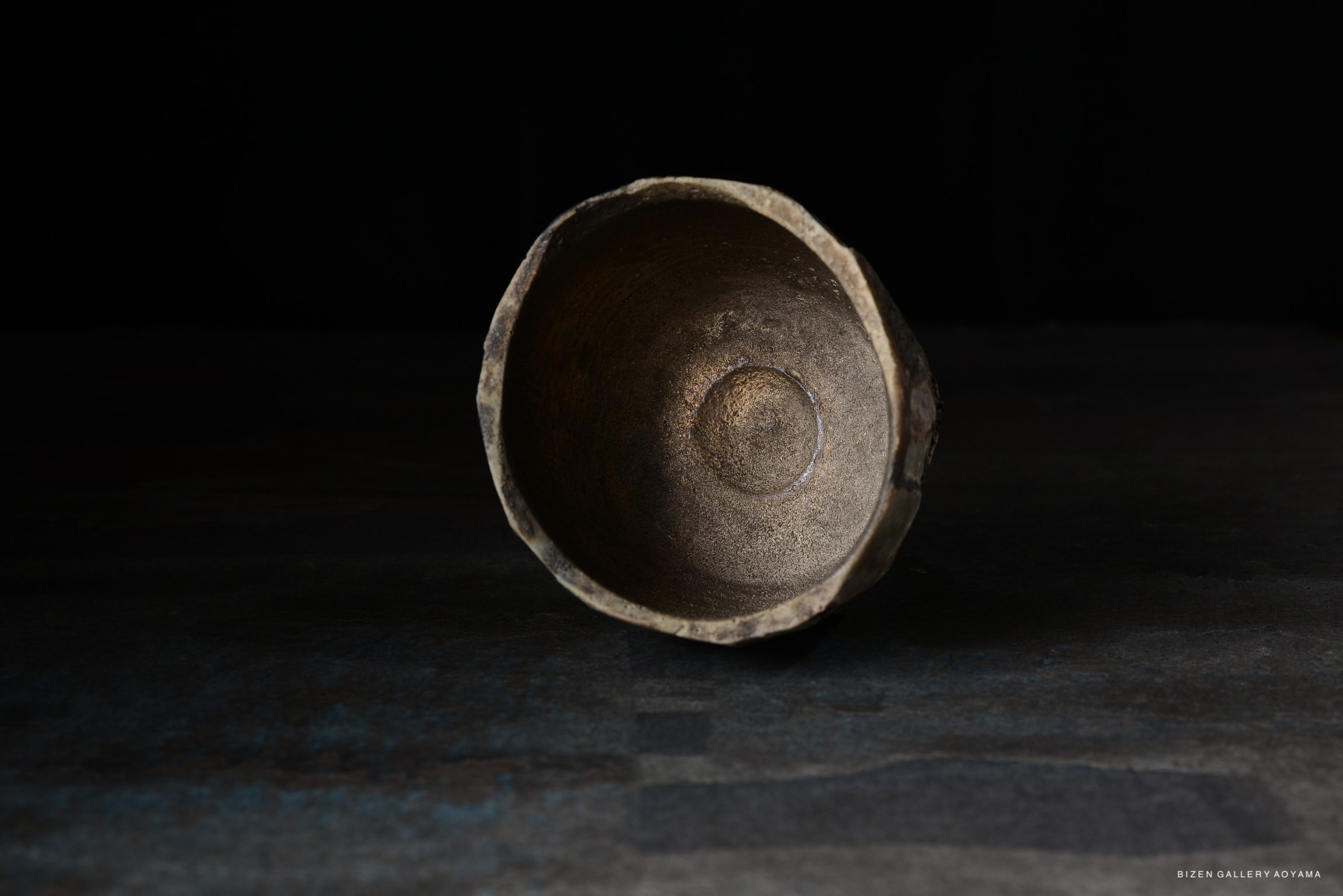 A close-up view of the interior of a textured, metallic bowl placed on a dark surface.