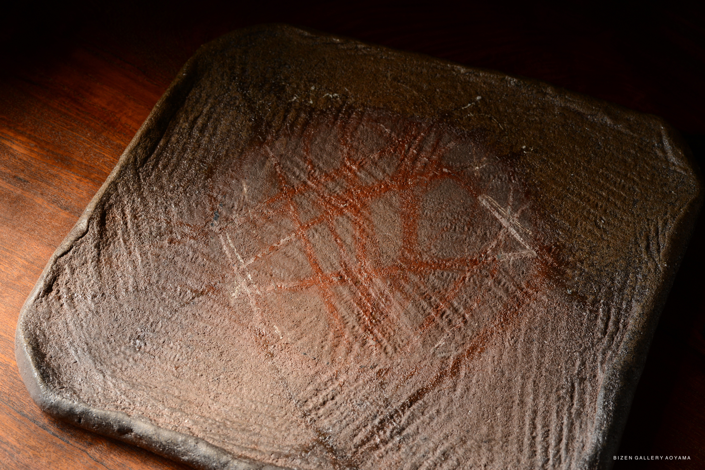 Close-up of a textured, rectangular clay surface with intricate patterns and markings.