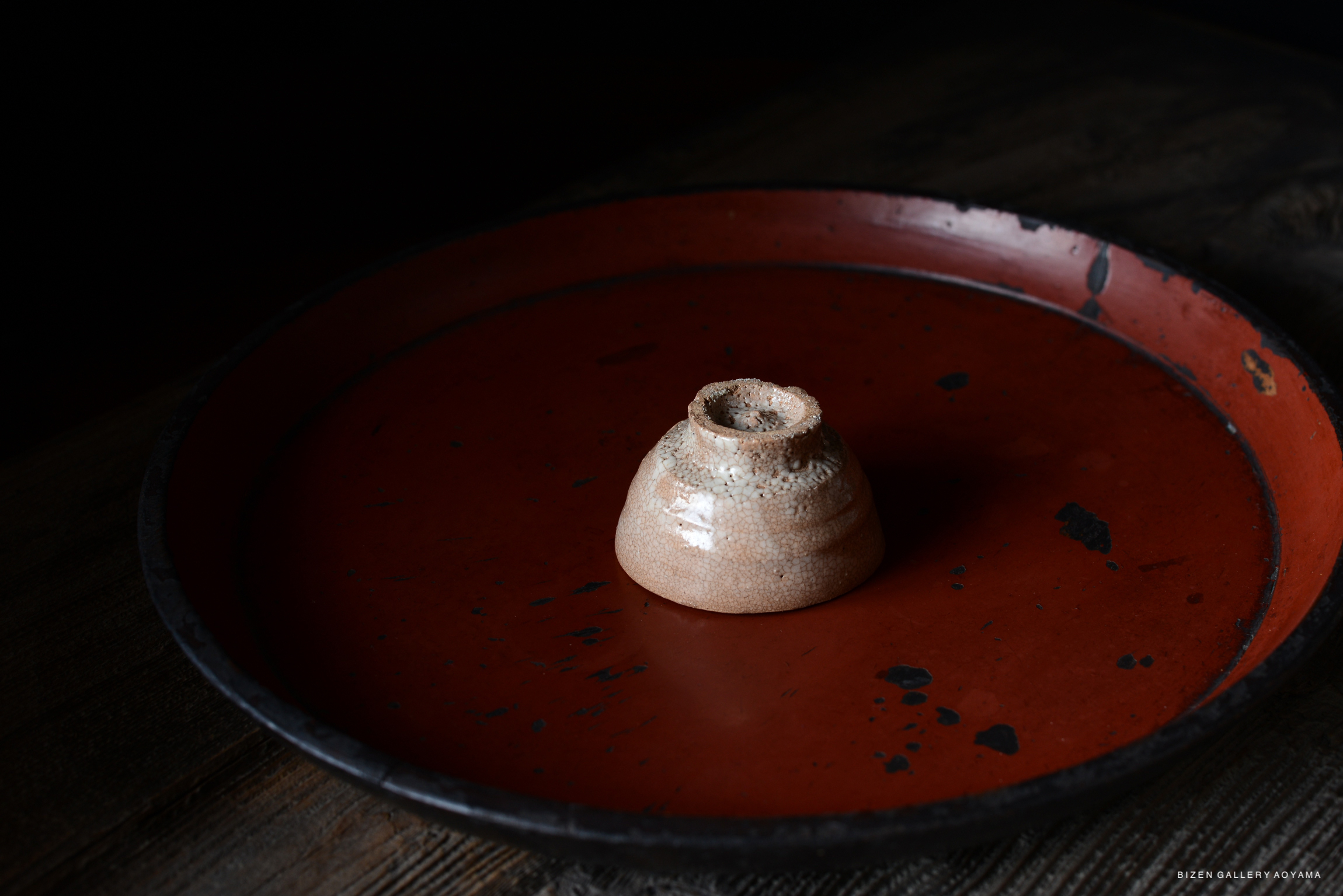 A close-up image of a ceramic bowl placed on a red tray with a rustic wooden background.