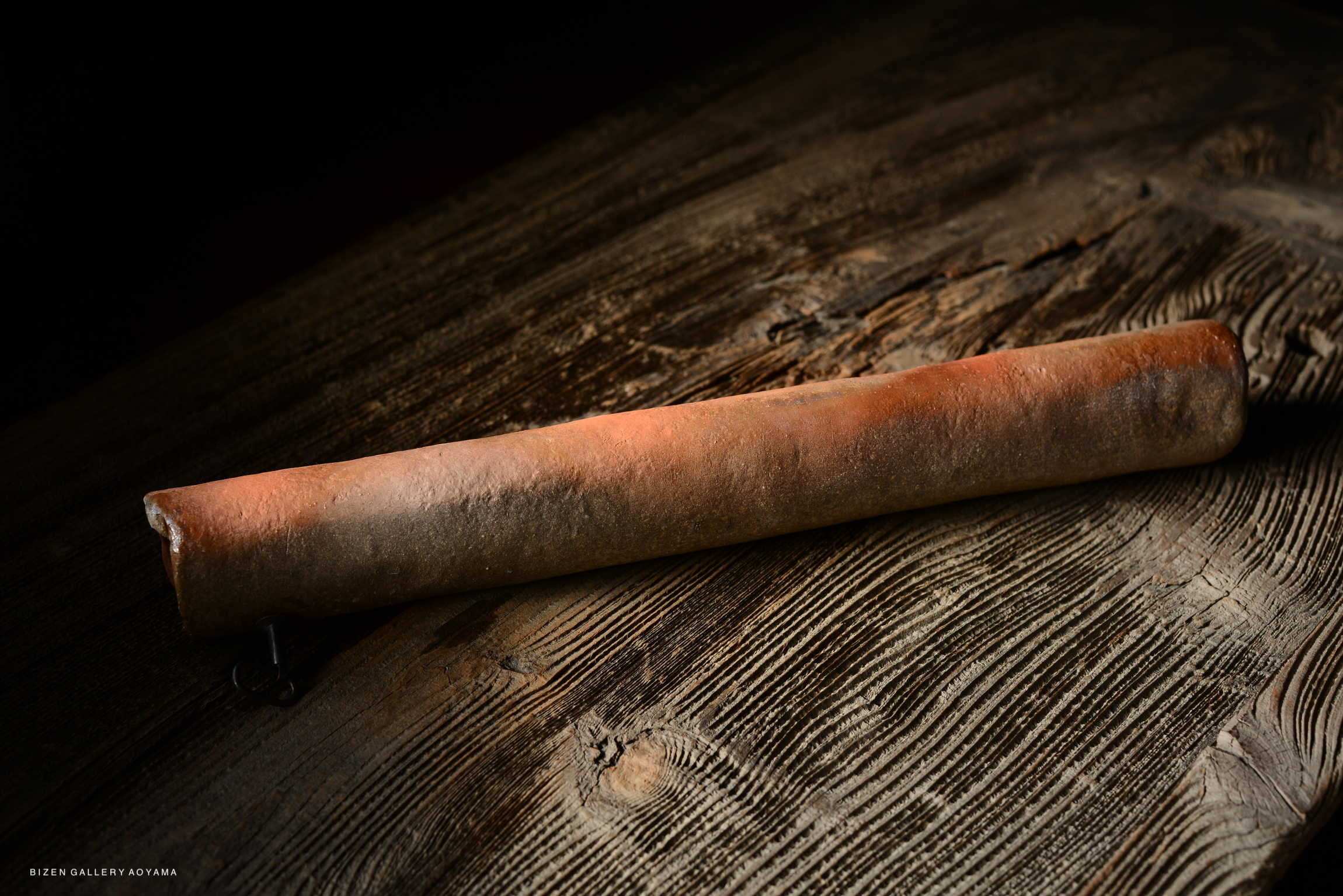 A Bizen Kakehanaire, a traditional Japanese ceramic tool, resting on a wooden surface.