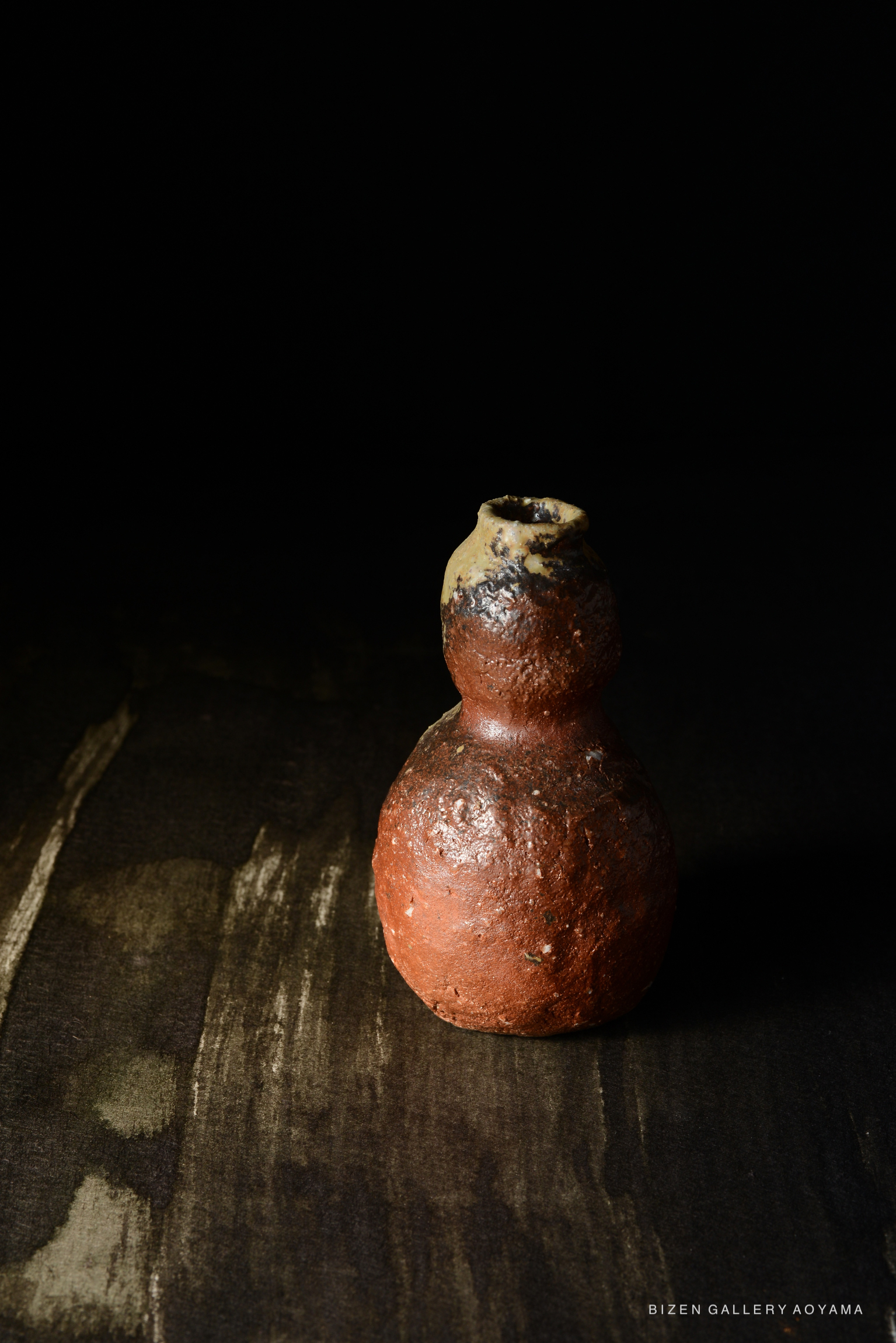 暗い背景に置かれた赤い壺型の陶器