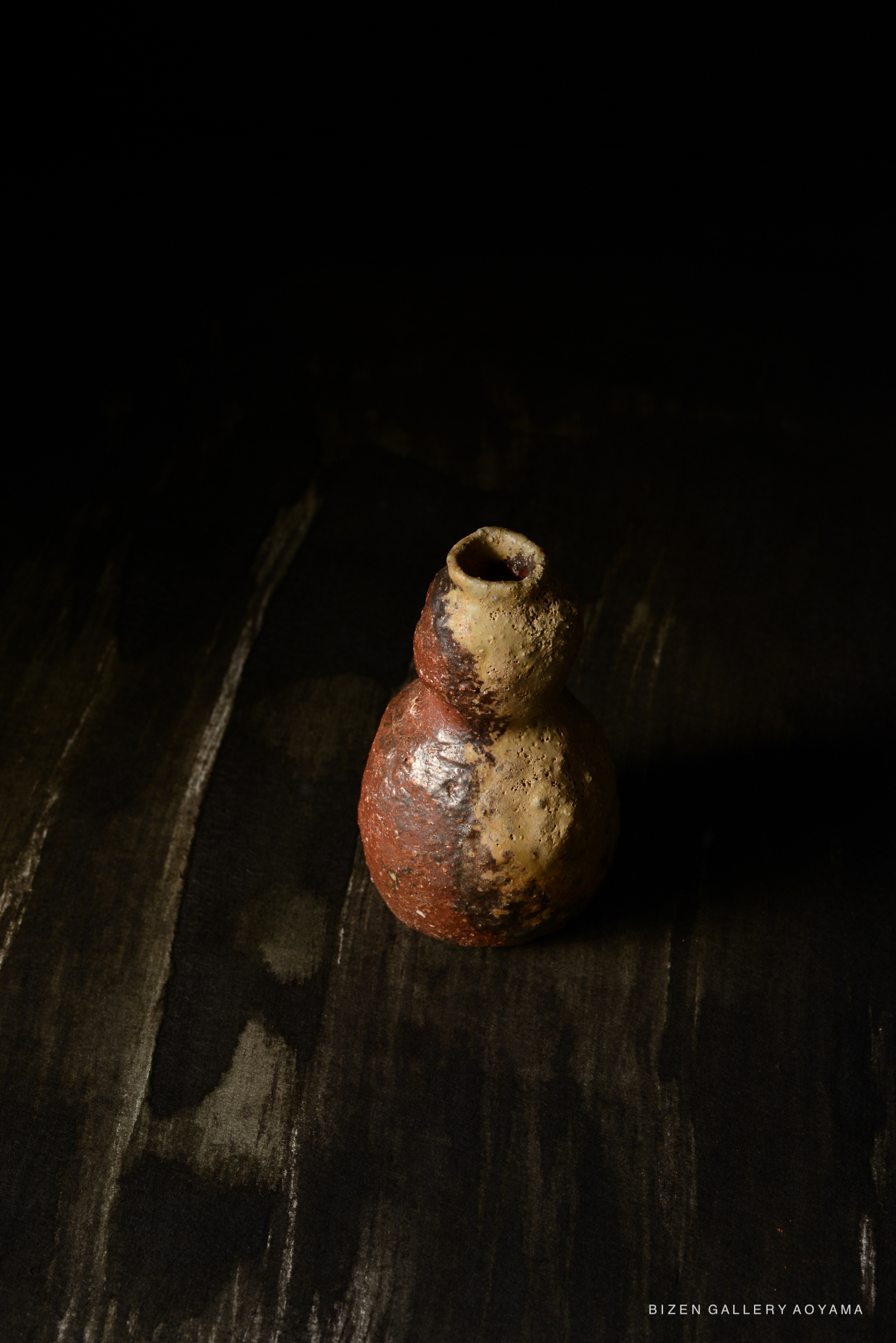 黒い背景の上にあるビゼン焼の陶器の壺