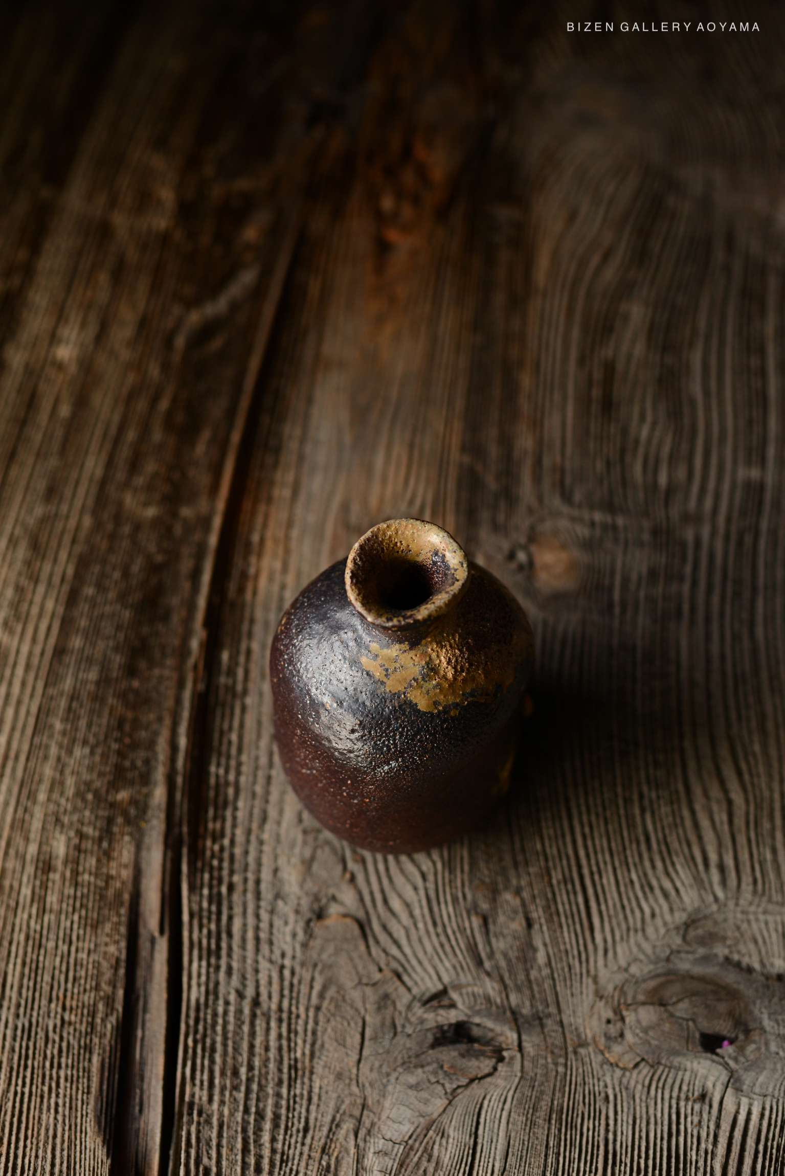 木のテーブルの上に置かれた、独特な形状の焼き物の壺。