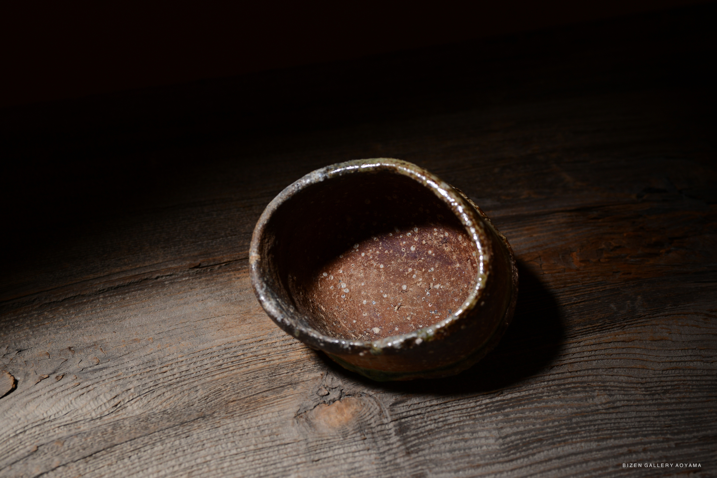 木のテーブルの上に置かれた、底が広く曲線状の陶器の器