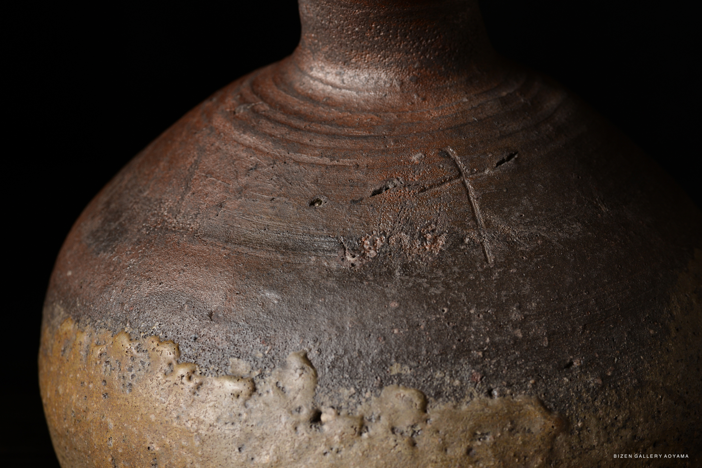 Close-up of a ceramic vase, showcasing its textured surface and earthy colors, with a notable brown and beige gradient.