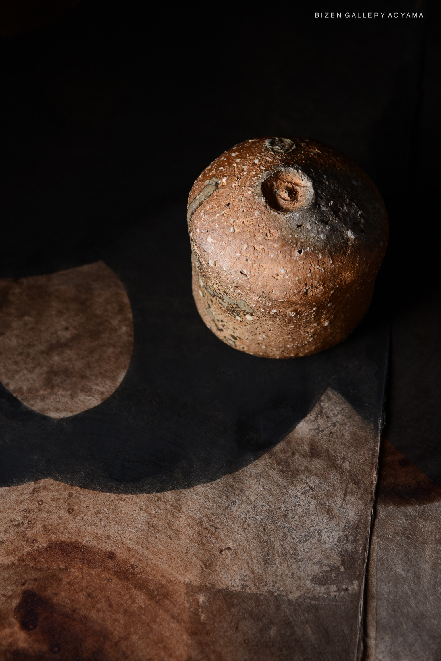 黒い背景の上に置かれた、土でできたオブジェのクローズアップ