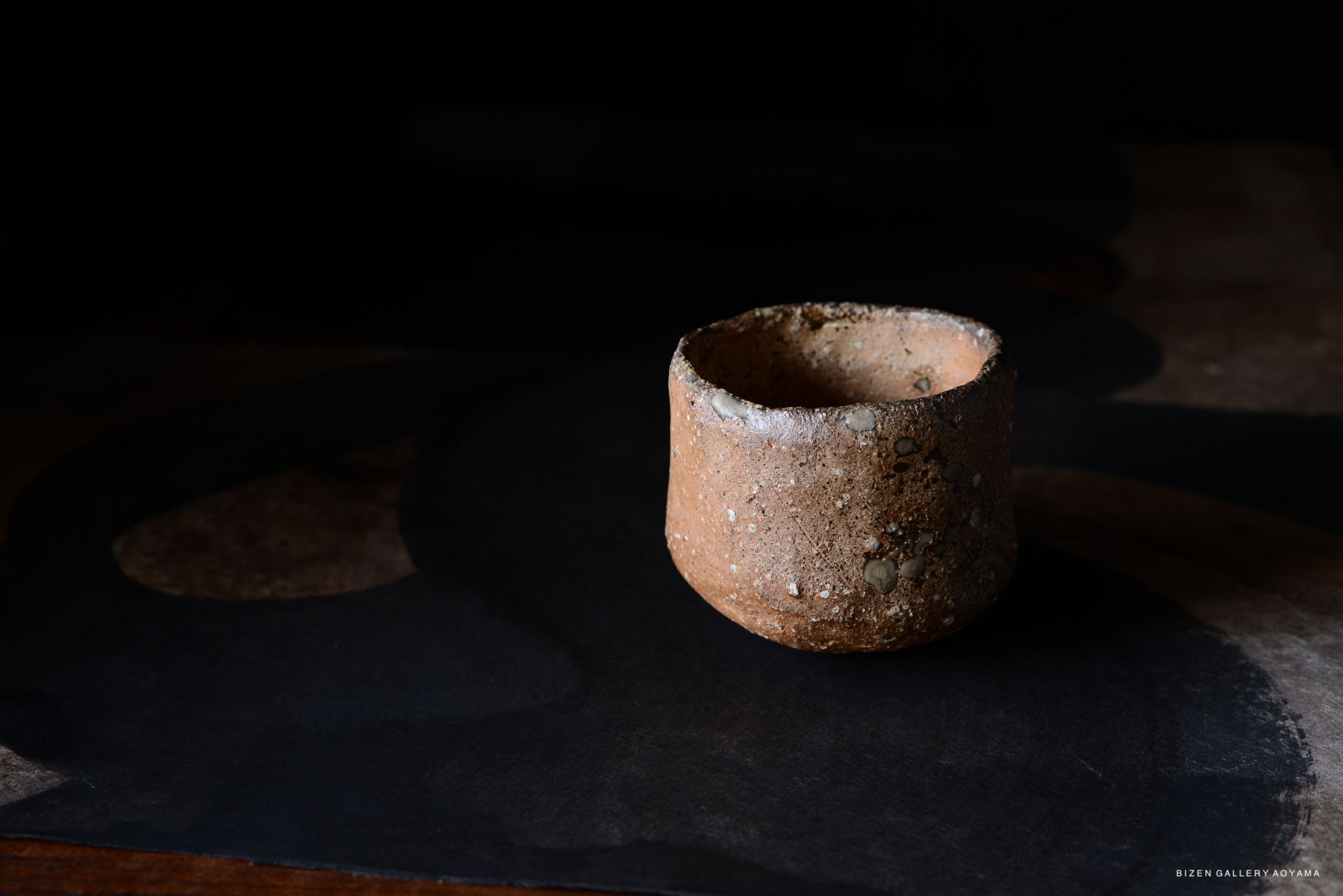 土製の器が暗い背景の上に置かれている写真