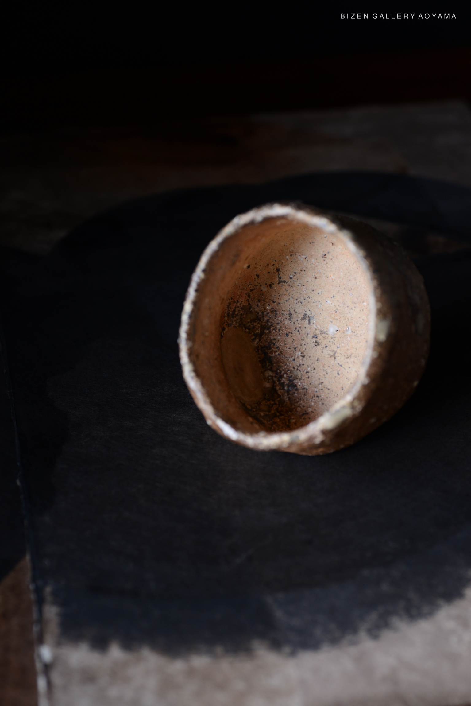 黒い背景の上に置かれたビゼン焼きの陶器の器