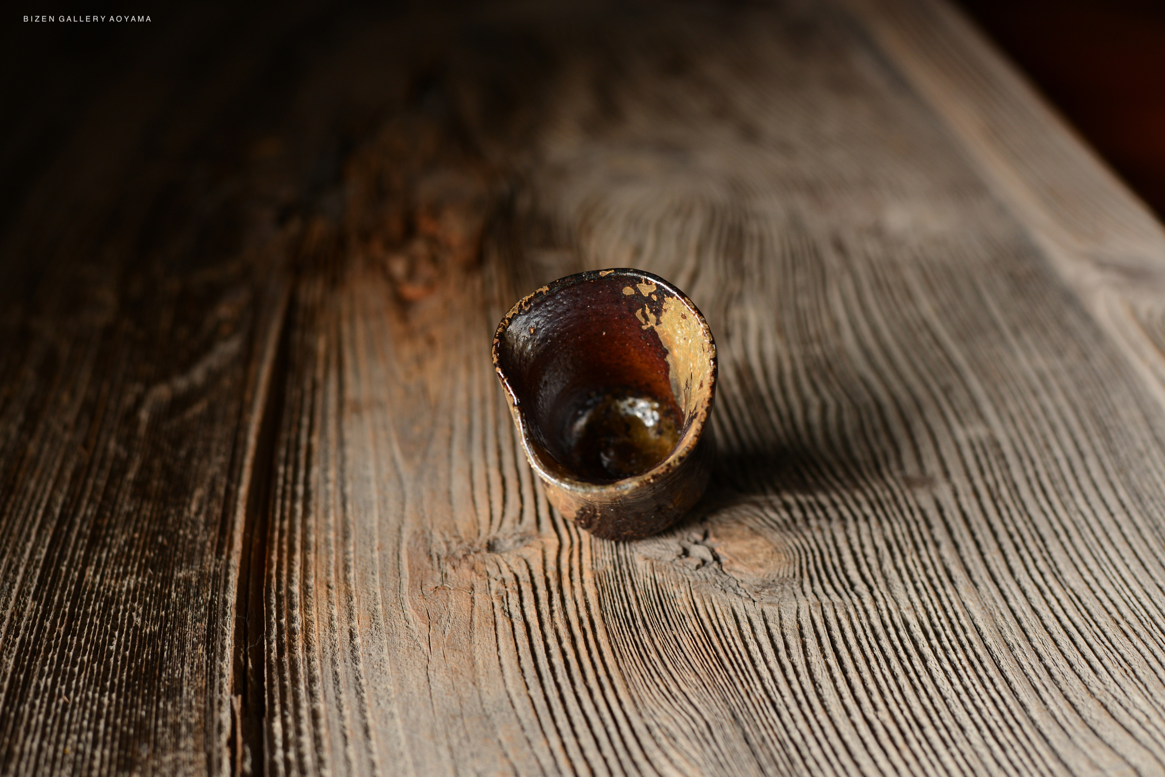 木製のテーブルの上に置かれた陶器のカップ