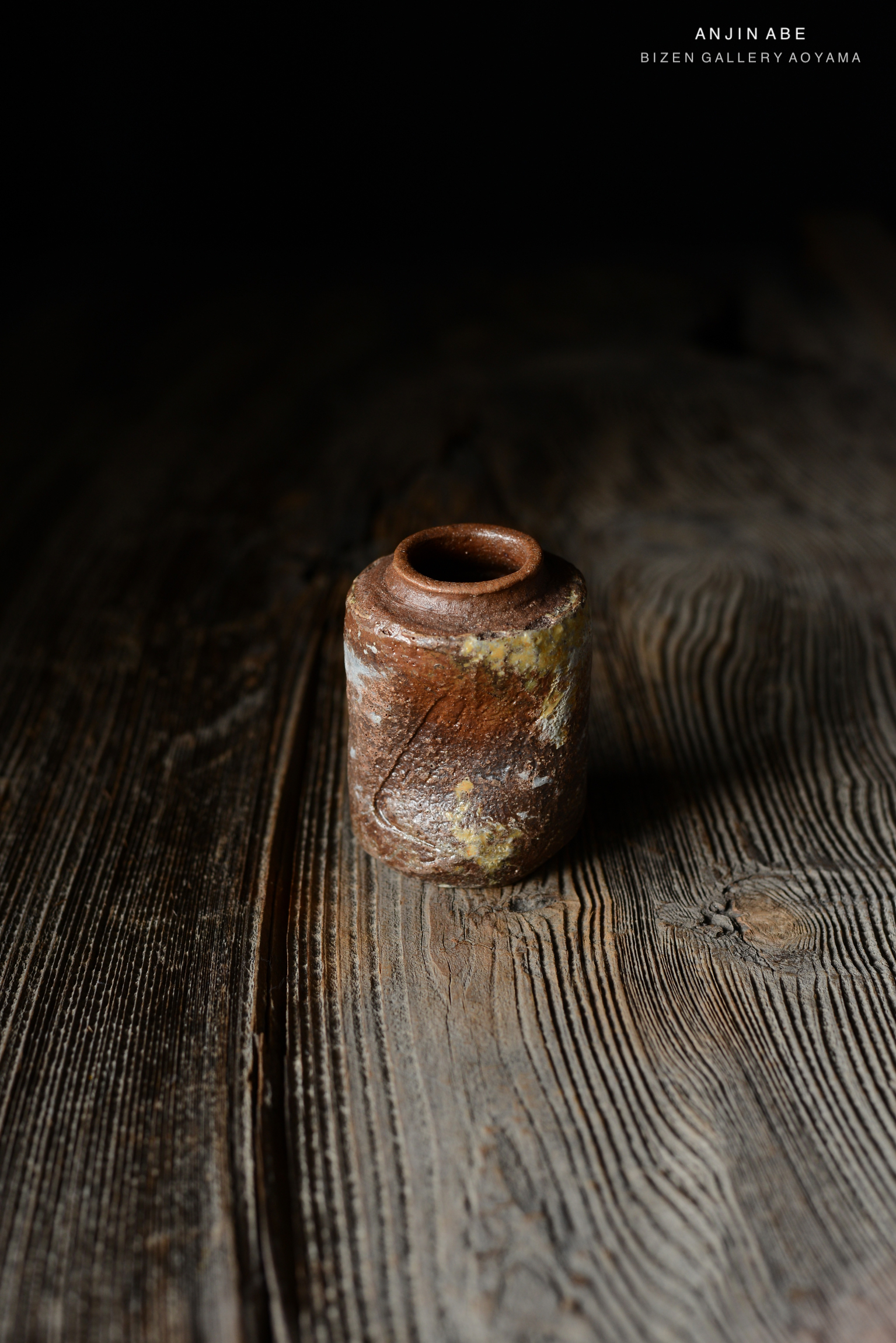 木のテーブルの上に置かれた茶色の陶器の容器