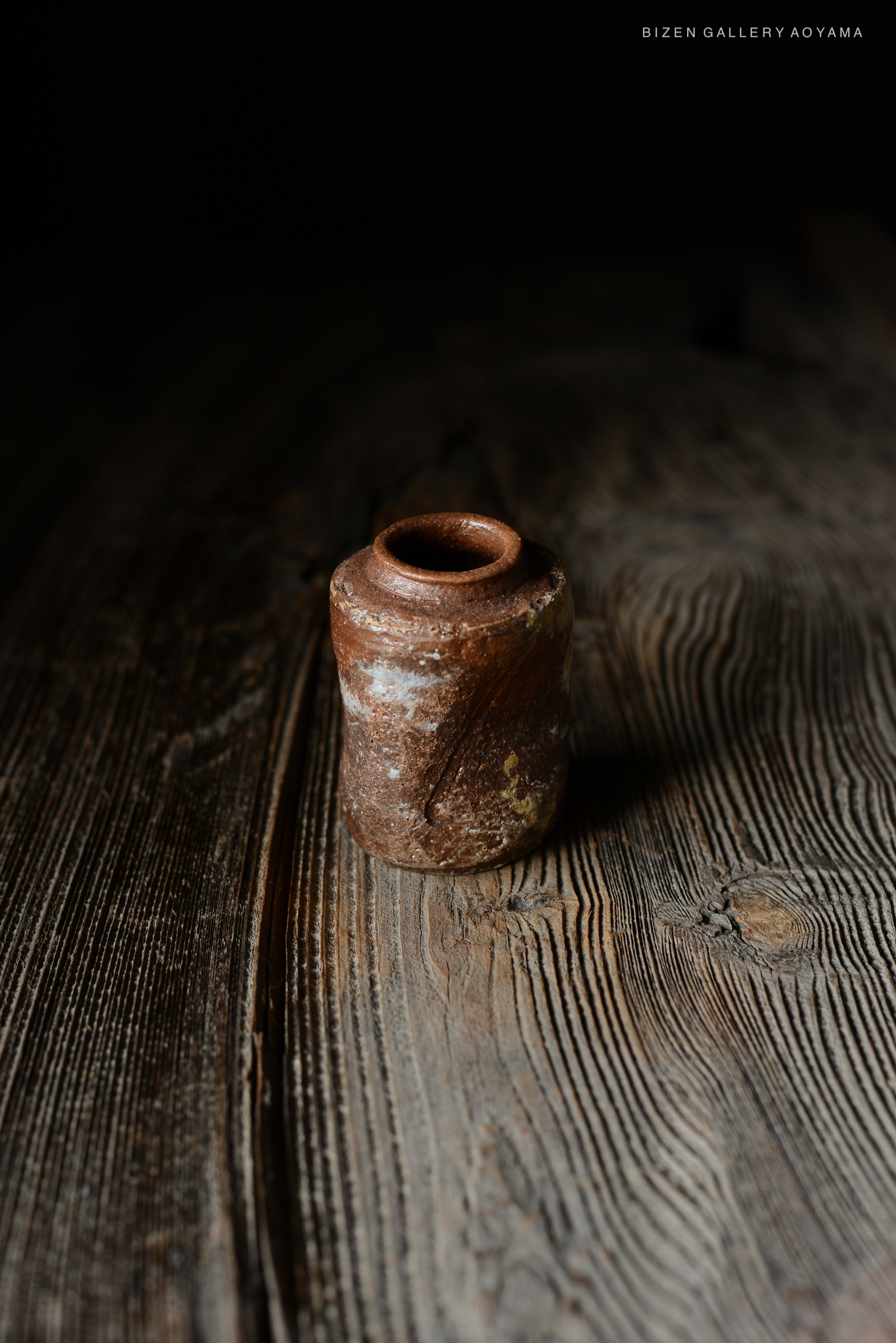 木製のテーブルの上に置かれた独特な形状の茶色い陶器