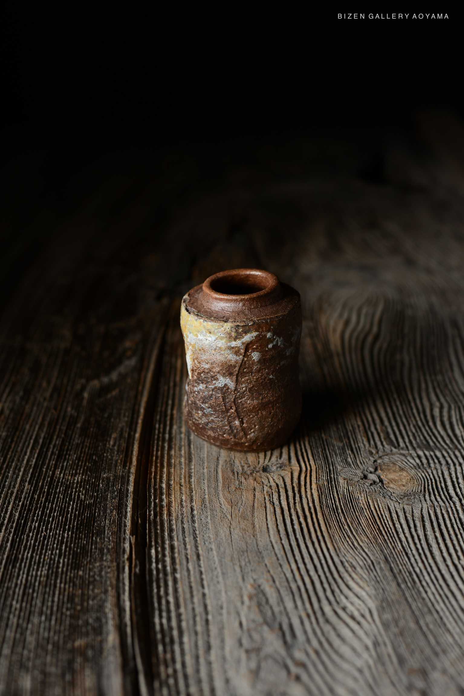 木のテーブルの上に置かれた焼き物の壺