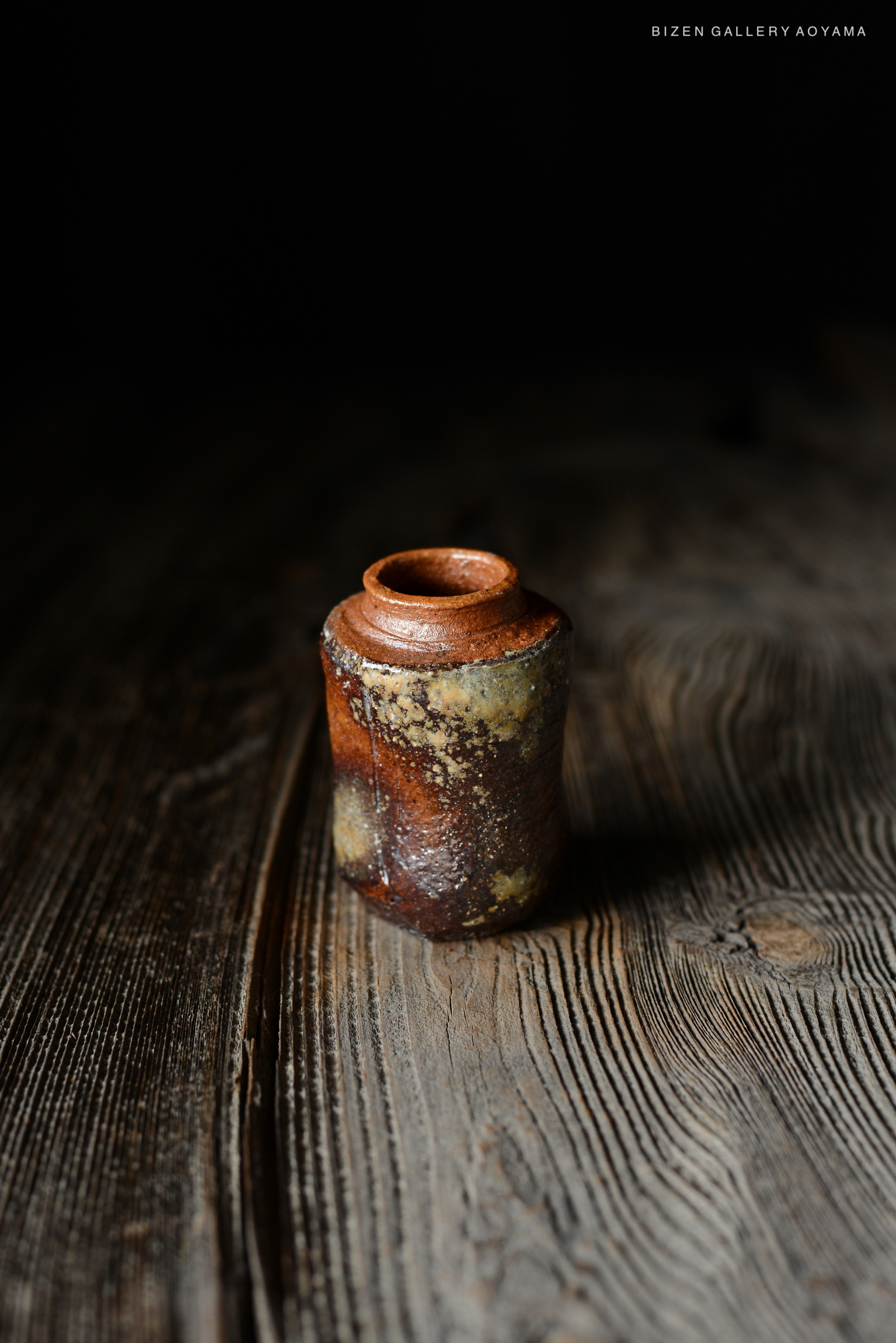 古い陶器の瓶が木のテーブルの上に置かれている。