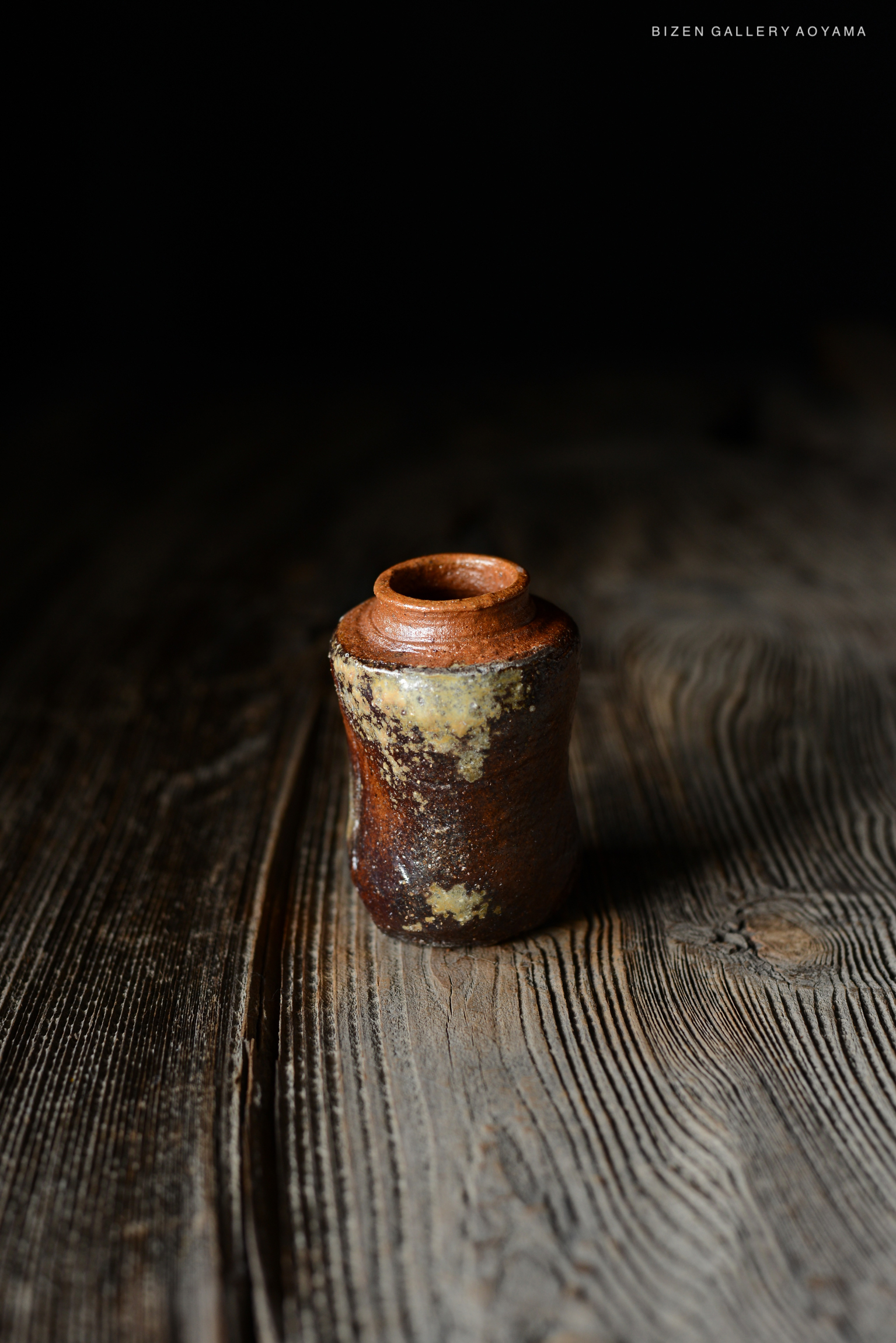 木製のテーブルの上に置かれた陶器の壺