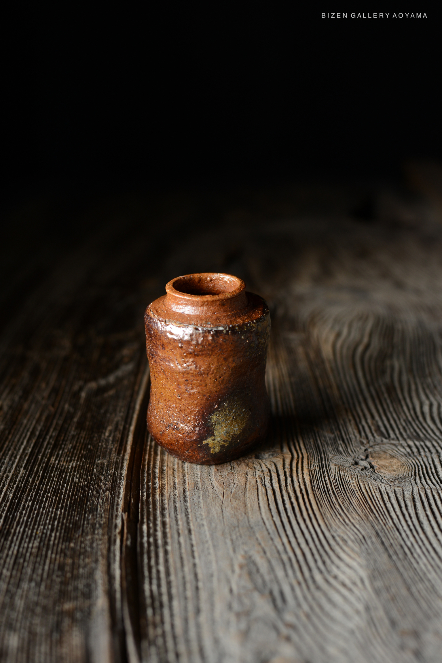 暗い背景の上に置かれた陶器の小瓶。