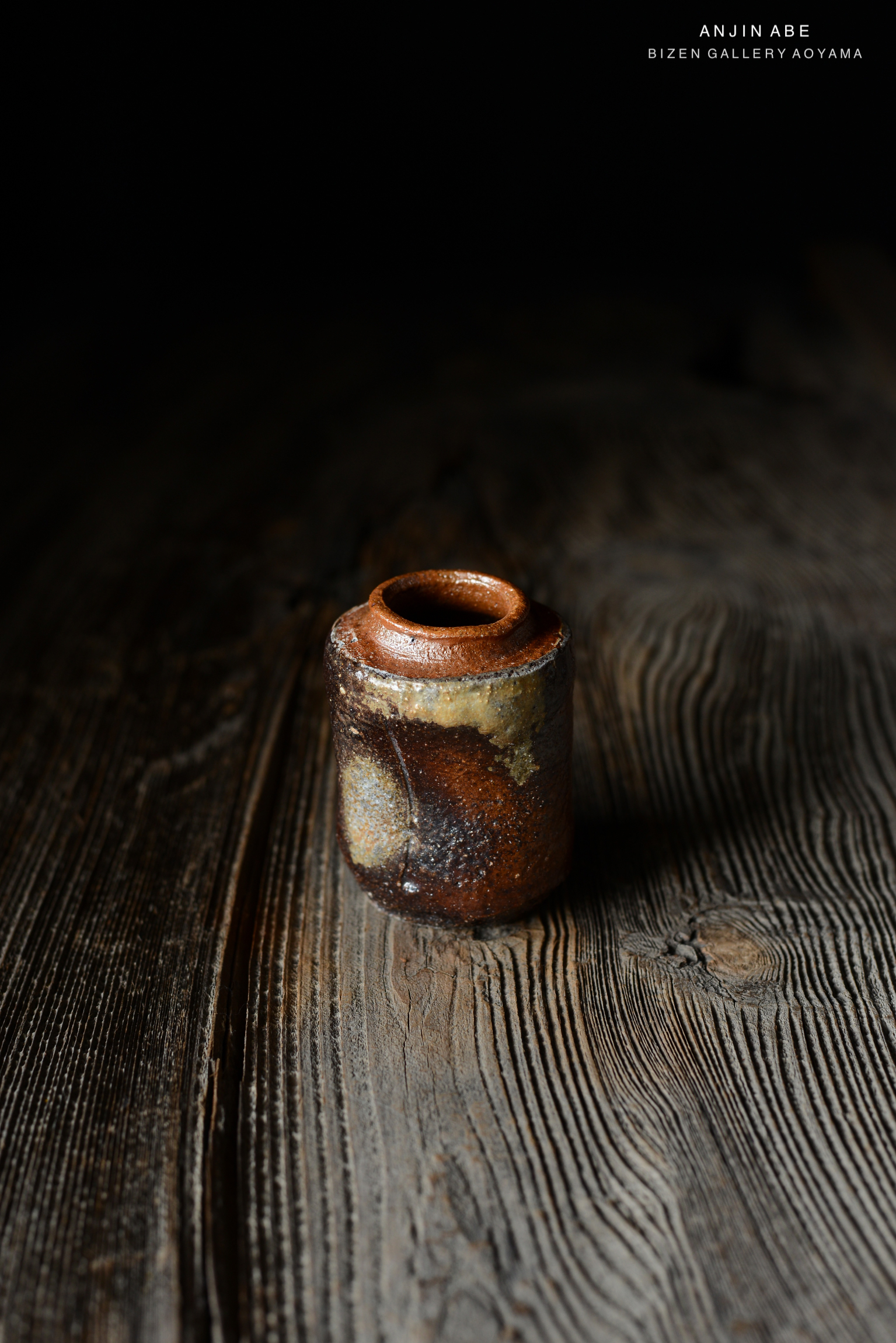 朴素で温かみのあるビゼン焼きの小型の陶器が、木のテーブルの上に置かれている。